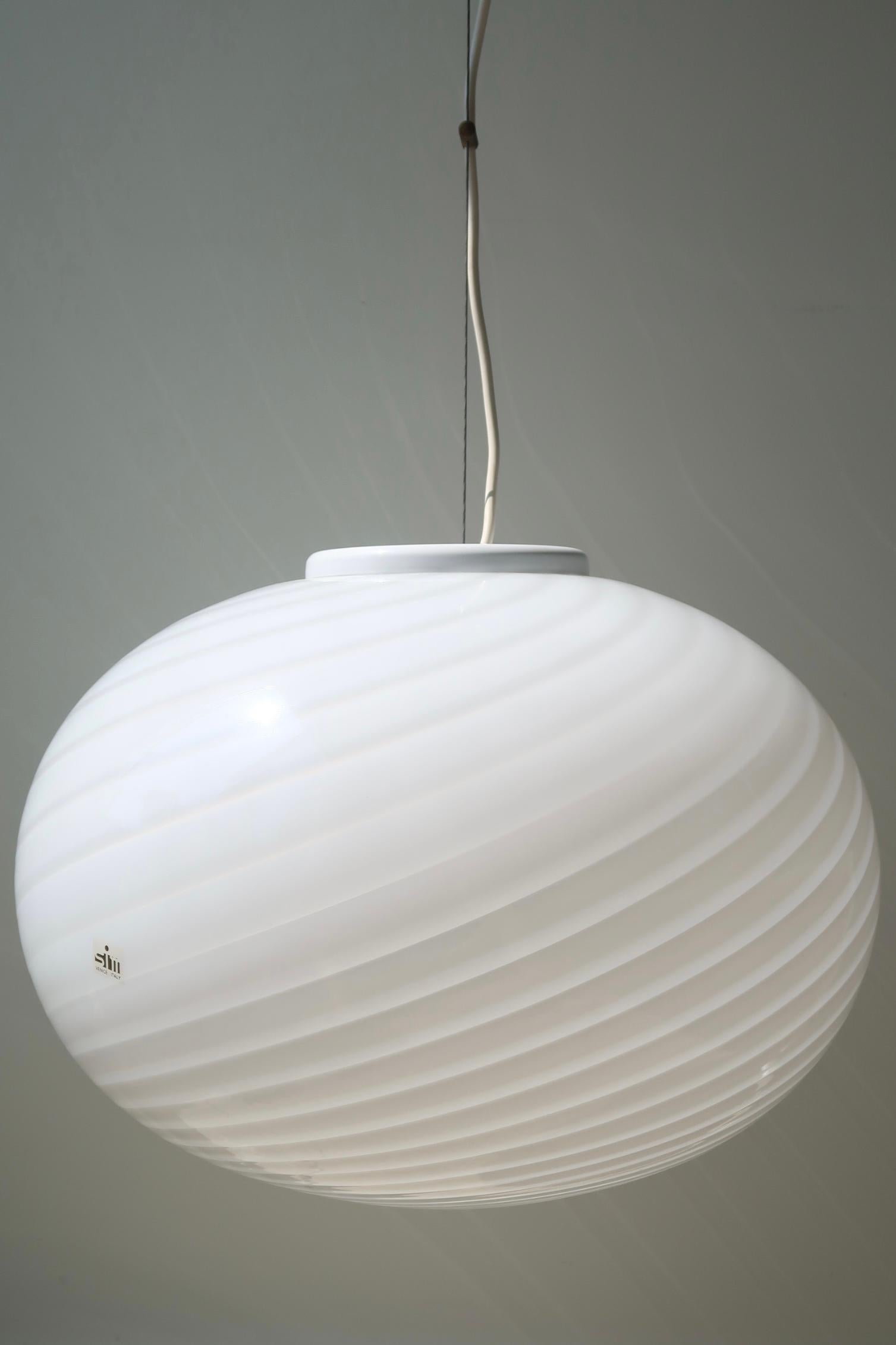 Extra large vintage Murano pendant ceiling lamp in white opaline glass. The glass is mouth-blown in an oval shape with a beautiful swirl pattern. Handmade in Italy, 1970s, and comes with adjustable suspension and original label.
D: 45 cm
