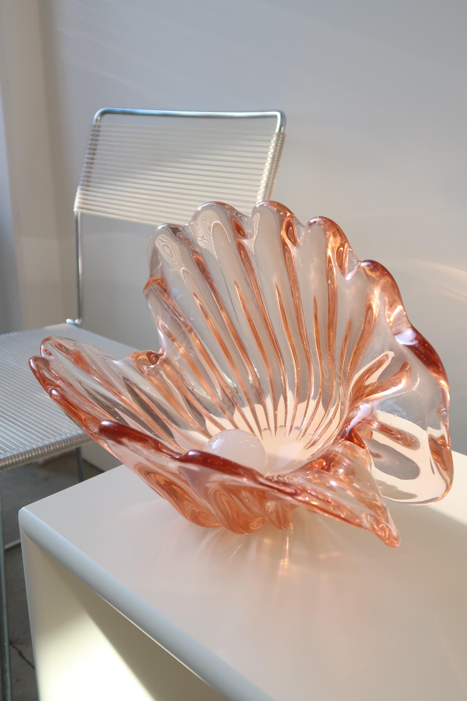 Vintage giant Murano shell clam bowl in transparent salmon colored glass with large white glass pearl. Both shell bowl and pearl are mouth blown. The shell has two bases and can either stand upright or tip on its side, the pearl itself lies loosely