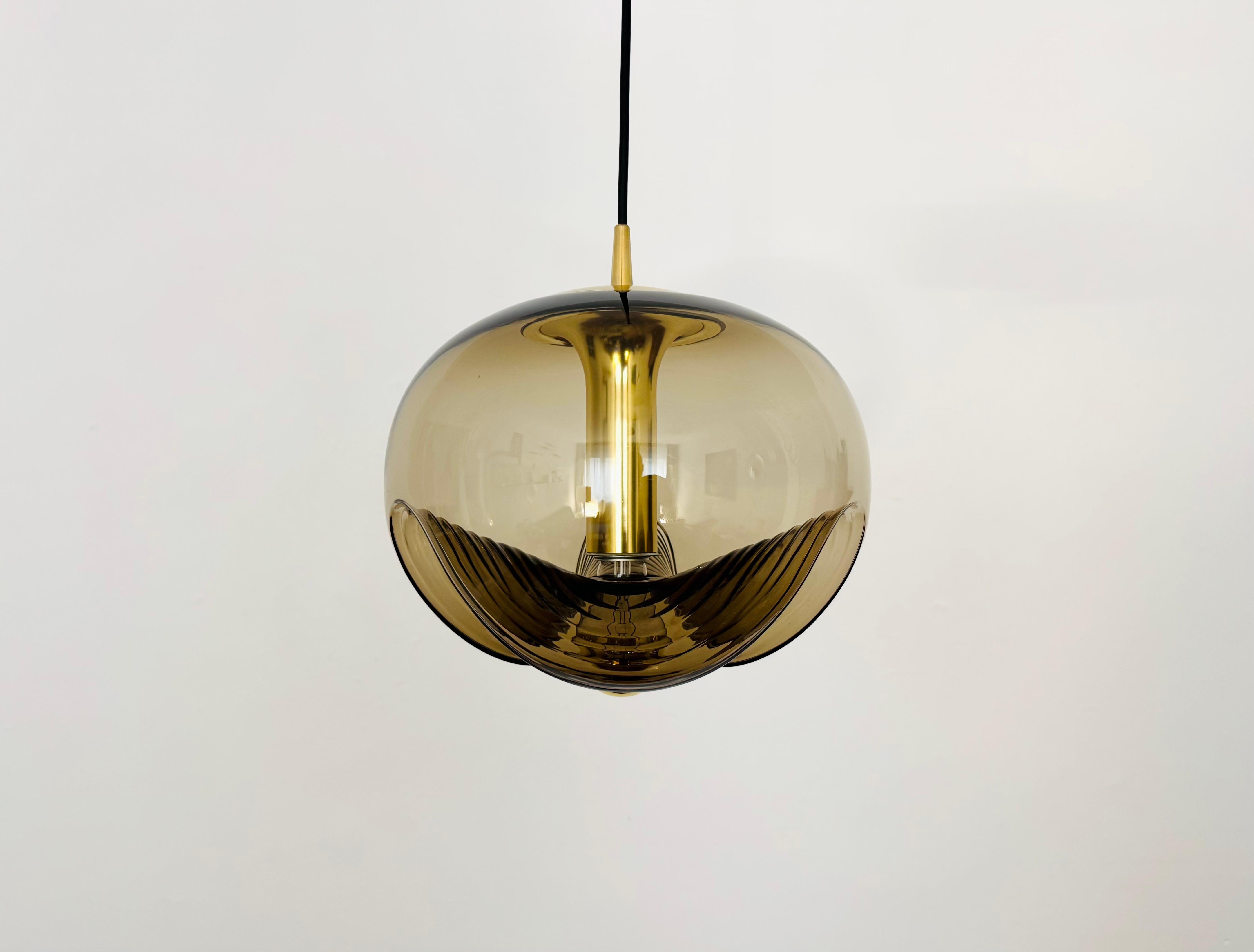 Lampada a sospensione in vetro fumé eccezionalmente bella e grande degli anni '60.
Il design e i materiali creano un fantastico gioco di luci nella stanza.
Una lavorazione di altissima qualità e un valore aggiunto per qualsiasi casa.

Produttore: