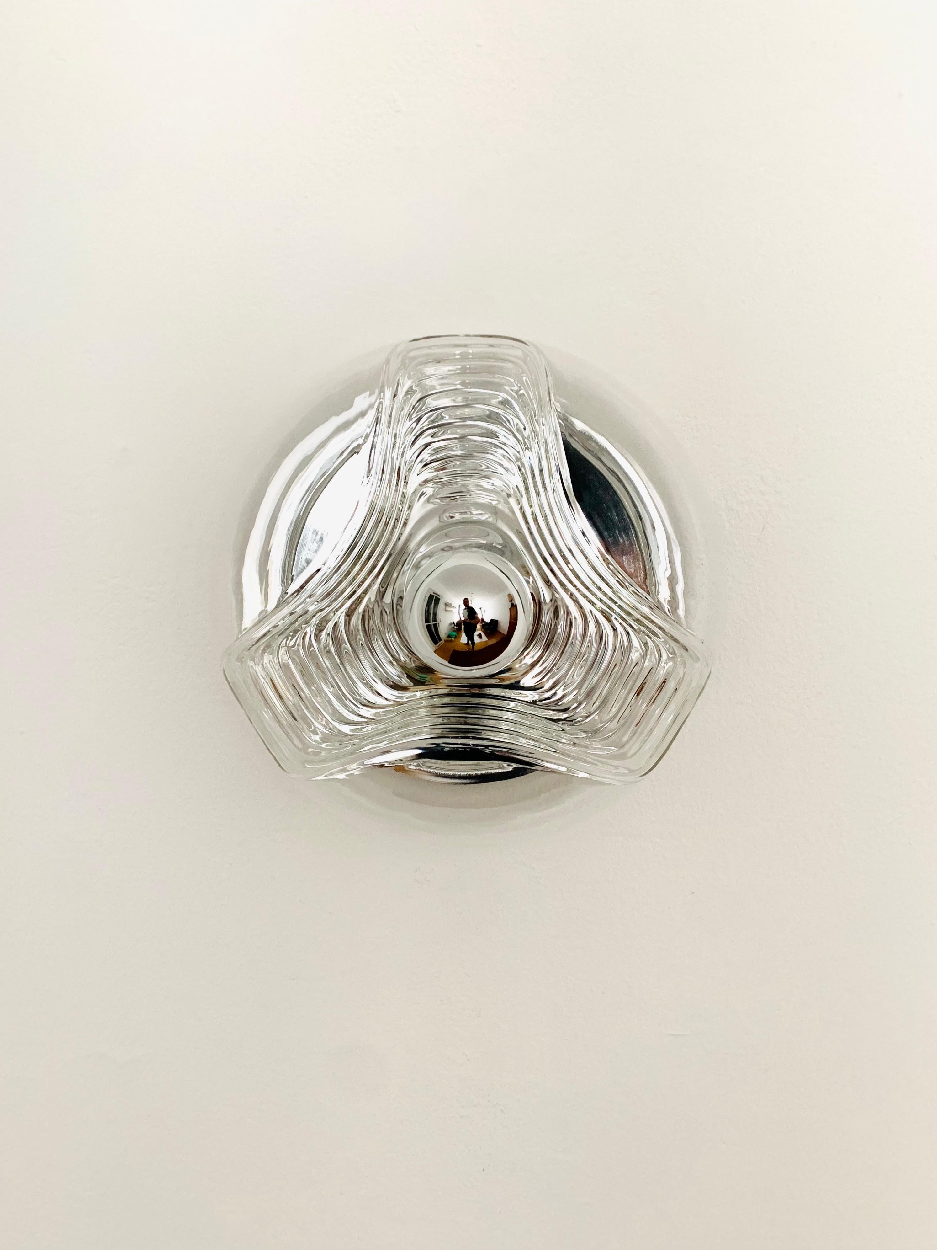 Exceptionally beautiful and large wall lamp or ceiling lamp from the 1960s.
The design and materials create a fantastic play of light in the room.
Very high-quality workmanship and an enrichment for every home.

Manufacturer: Peill and