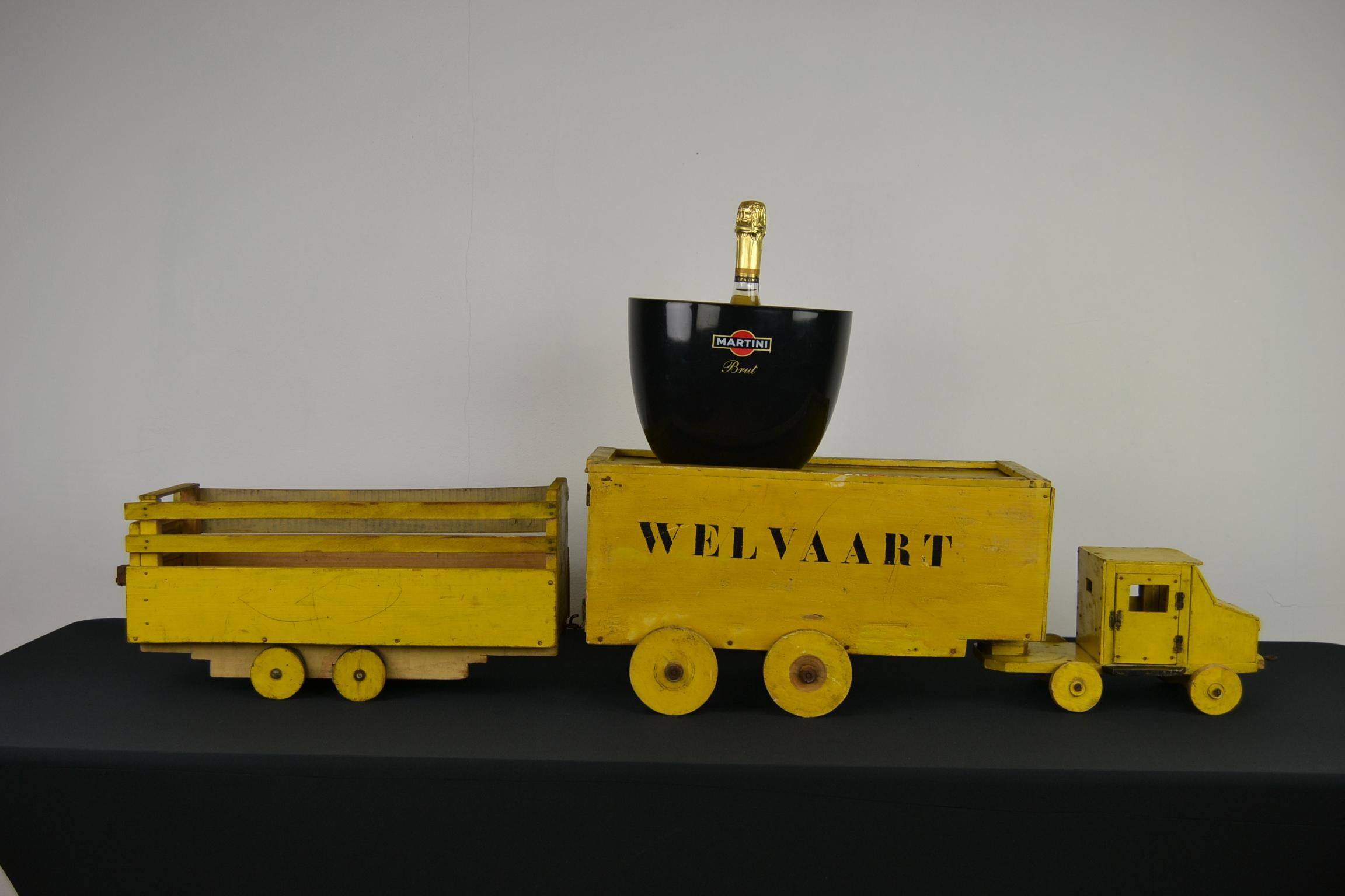 Folk Art wooden toy truck with trailers.
This extra large wooden toy consists of 3 pieces: a cabin with 2 livestock trailers, all in yellow painted color. 
The cabin has 2 doors which can be opened. The middle trailer has a roof which can be slided