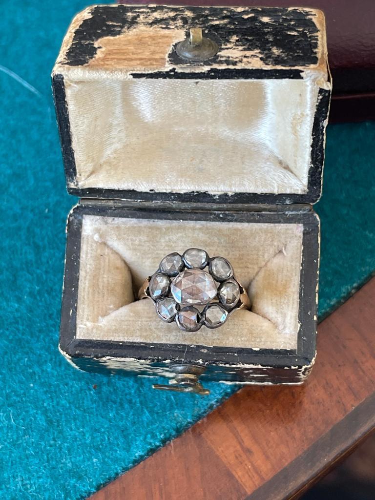 A grand seventeenth century Georgian cluster engagement ring adorned with an array of glistening European cut diamonds arranged in a flower shaped face.

A Central old European cut with 0.70 carats surrounded 8 rose cut diamonds with a total weight