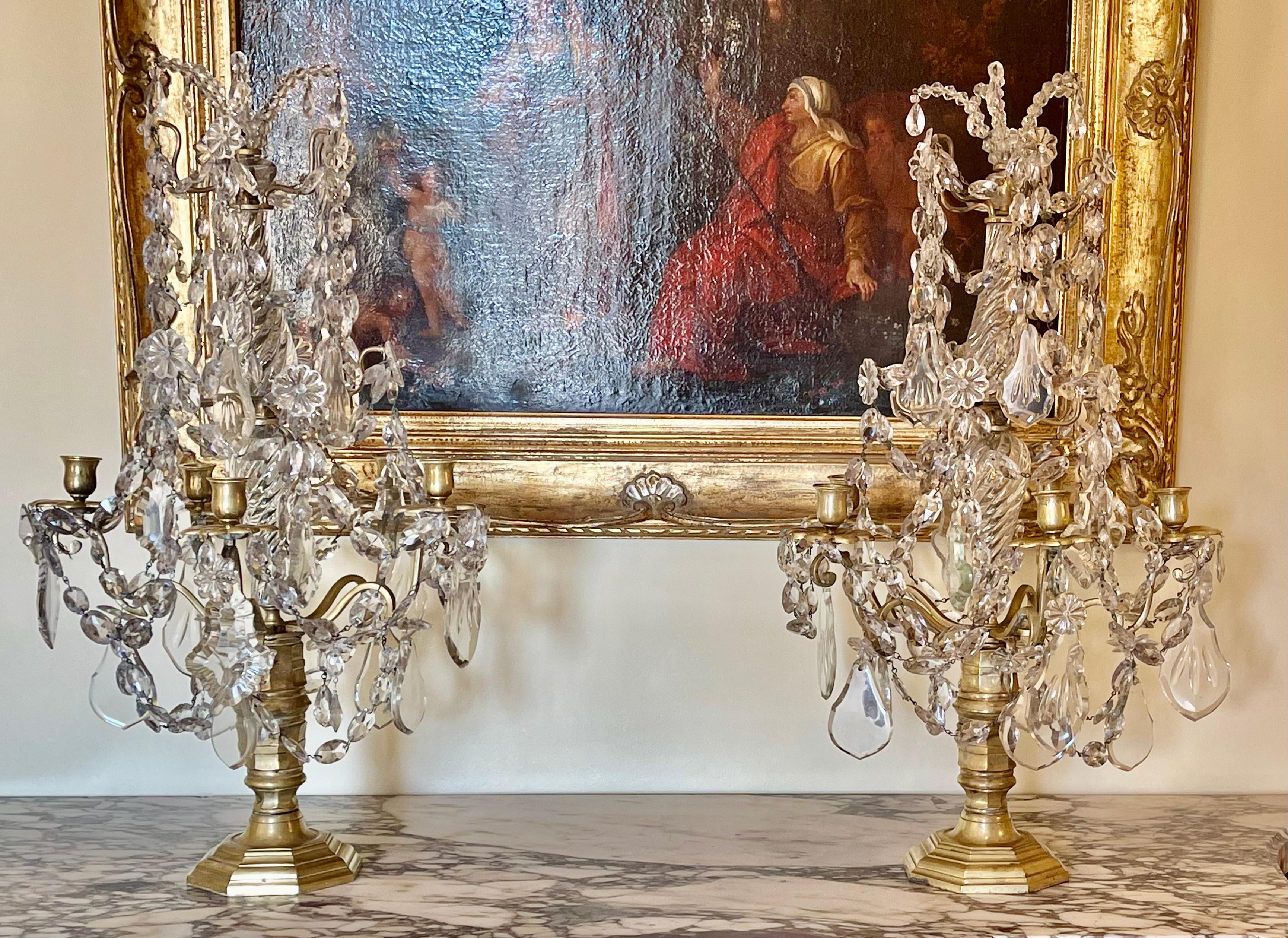 Sumptuous pair of Louis XIV period crystal and bronze candelabra dating from the 17th century.
They are complete and in good condition. Each girandole has 5 lights adorned with tassels with end candle holders. The whole is supported by a baluster