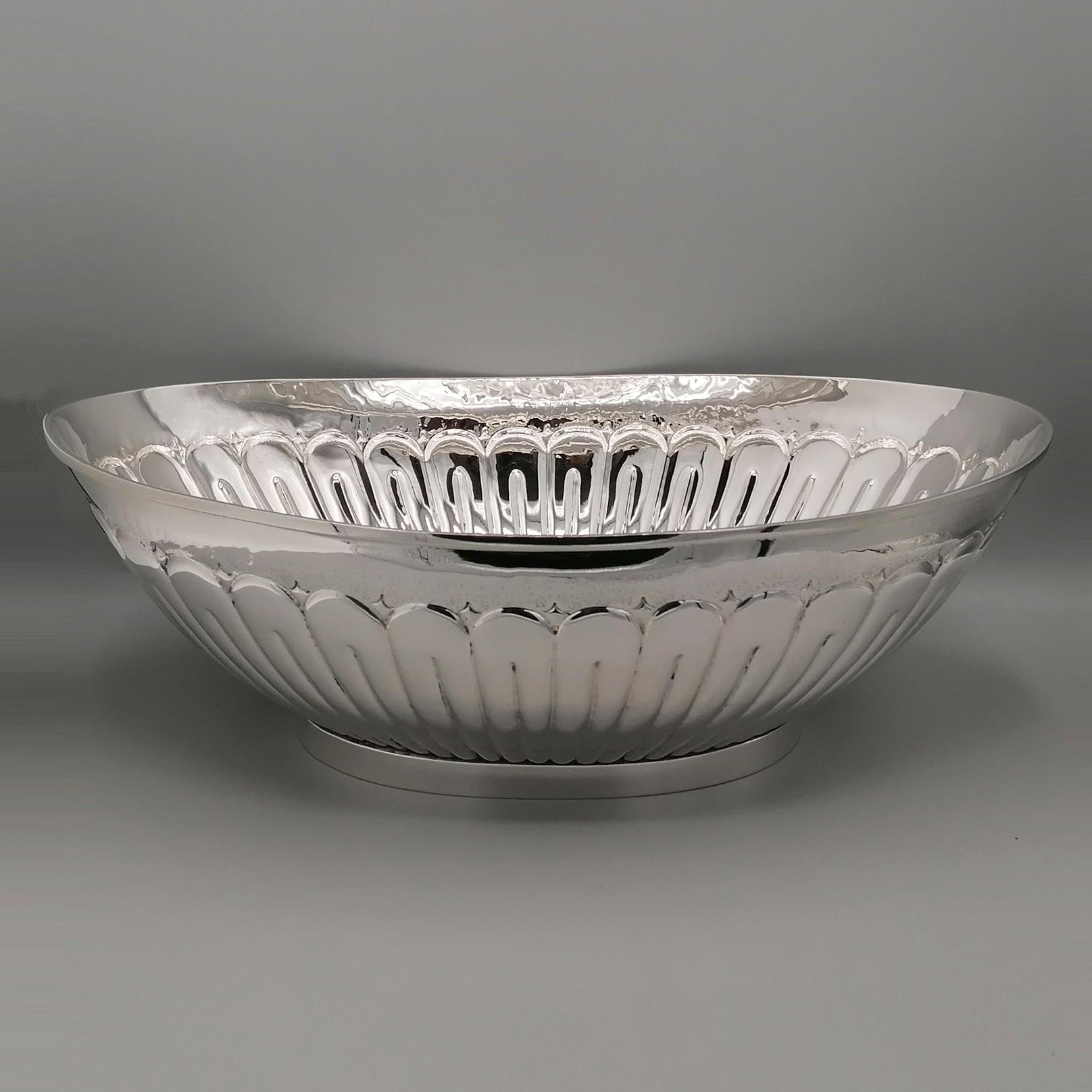 Oval centerpiece in solid 800 silver.
The body, very well proportioned and balanced in its shapes and lines, has been embossed with pod motifs.
The embossment was executed in an exemplary way, so much so that it appears very precise and elegant even