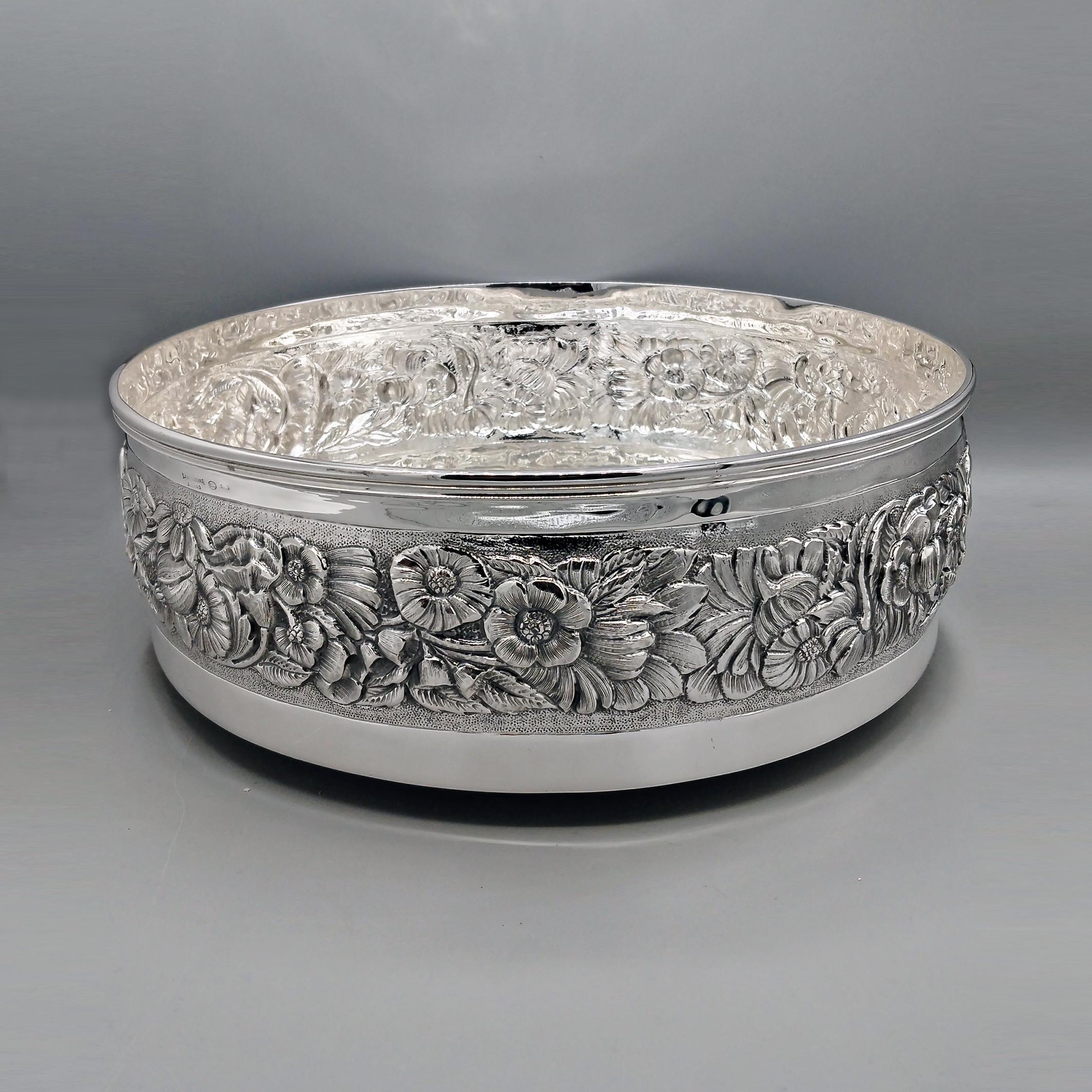 800 Centrotavola in argento con fiori in rilievo
Il centrotavola è rotondo con un bordo dritto.
Un motivo di fiori e foglie è impresso al centro della fascia esterna.
Lo spazio tra i fiori e le foglie è intricatamente martellato (zigrinato) per