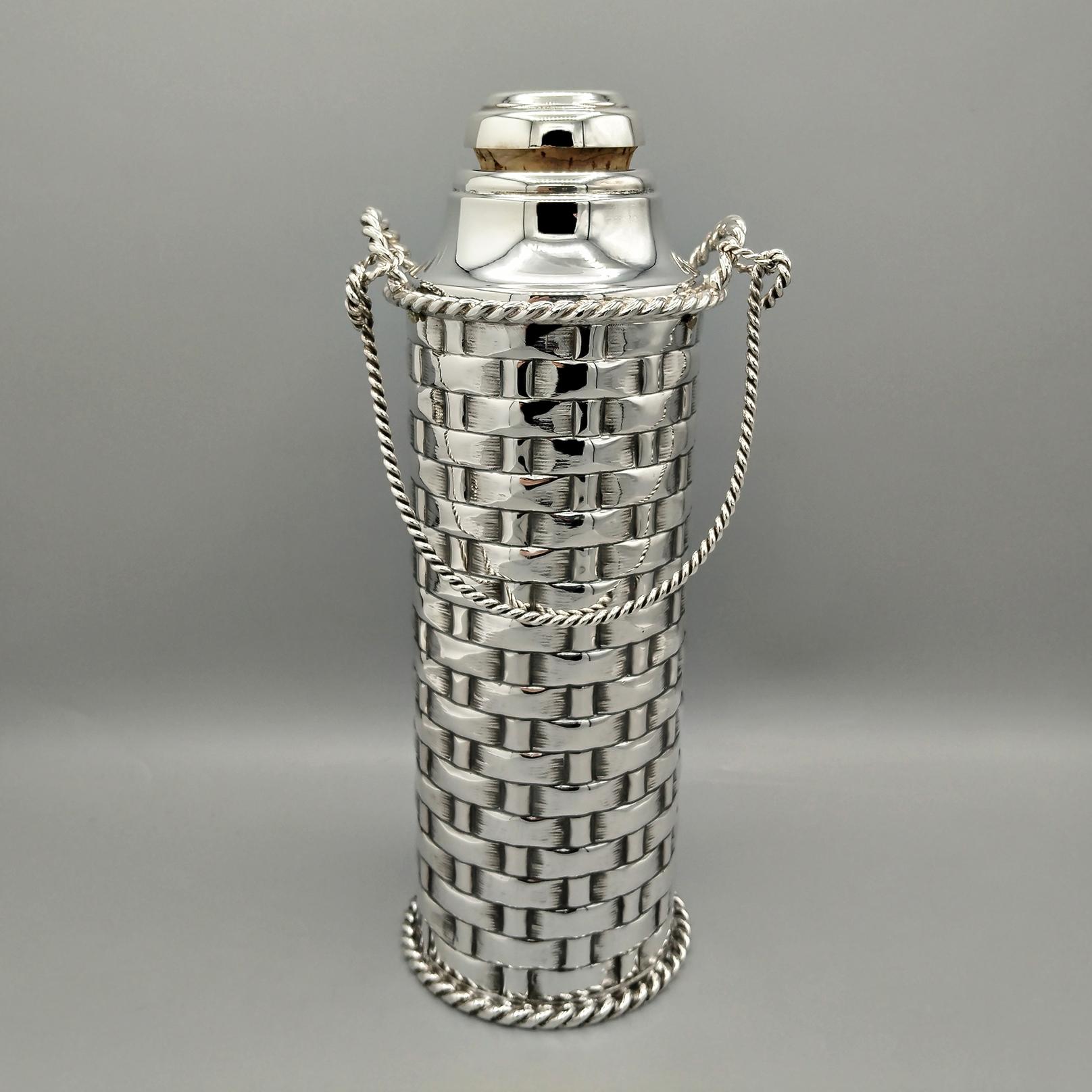 Termo para bebidas calientes en plata 800 maciza.
El termo es cilíndrico y se fabricó totalmente a mano a partir de una lámina de plata y después se repujó y cinceló en el cuerpo con un diseño que representa una cesta de mimbre.
En la parte superior