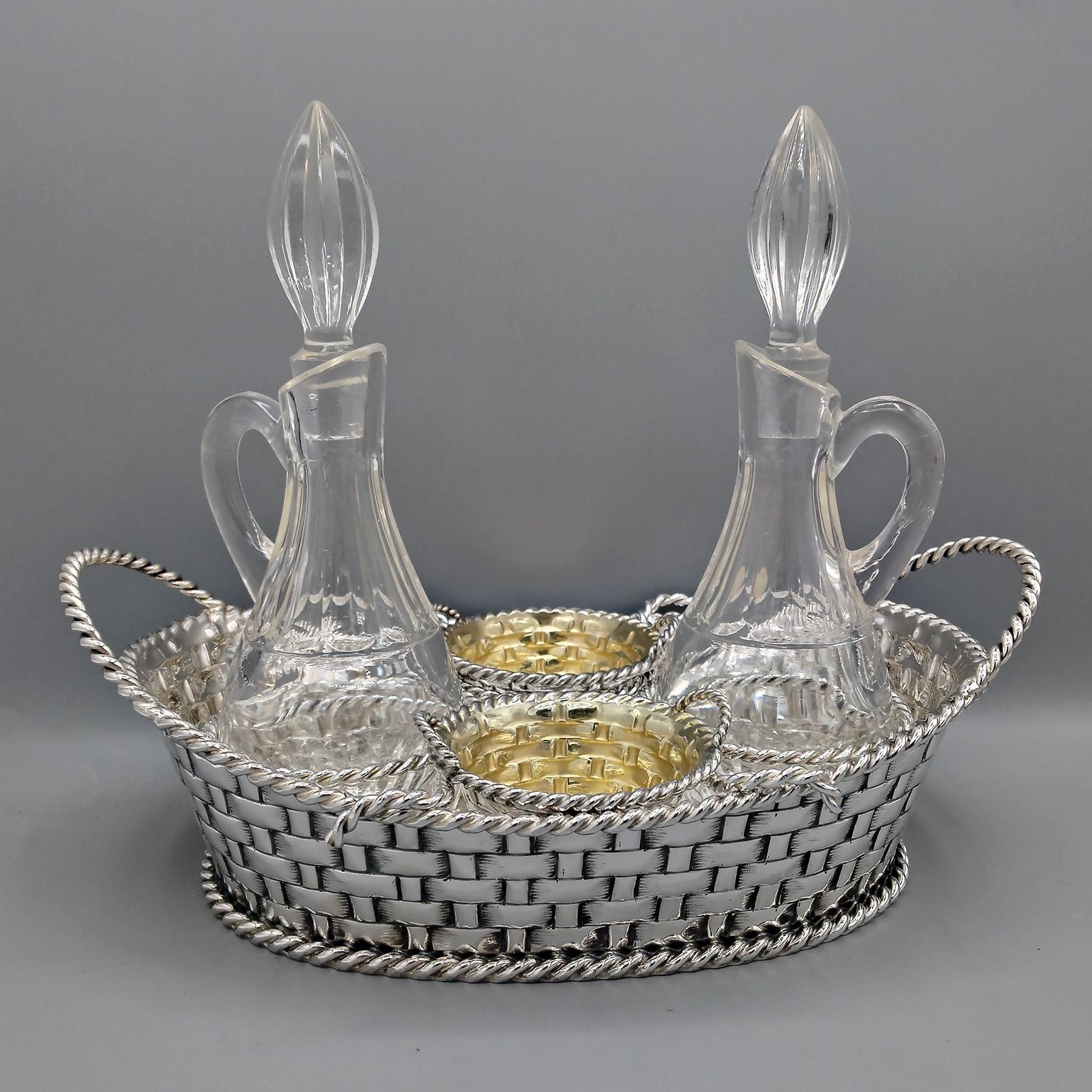 Aceitera ovalada de plata 800 maciza.
La cesta se fabricó totalmente a mano a partir de una lámina de plata y después se repujó y cinceló con un diseño que representa una cesta de mimbre.
En la parte inferior y superior se soldaron 2 alambres