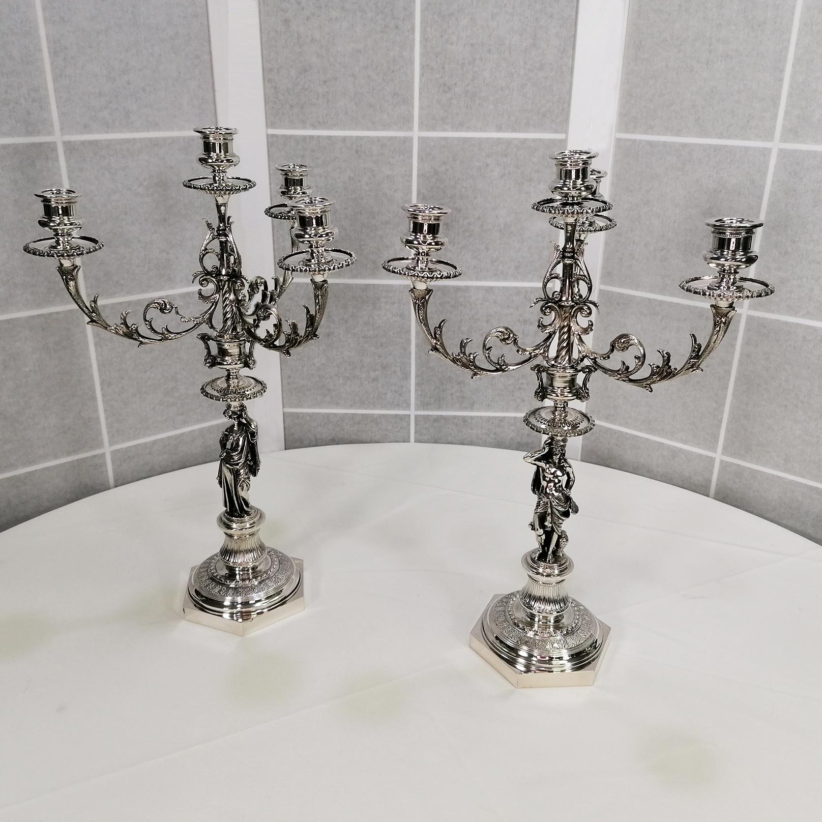 Pair of Italian 4-flame candelabra in neoclassical style.
The base is smooth hexagonal topped by a finely chiseled round base engraved with grooved column motifs.
A Greek Goddess made with the casting technique holds the arms of the candelabra, also