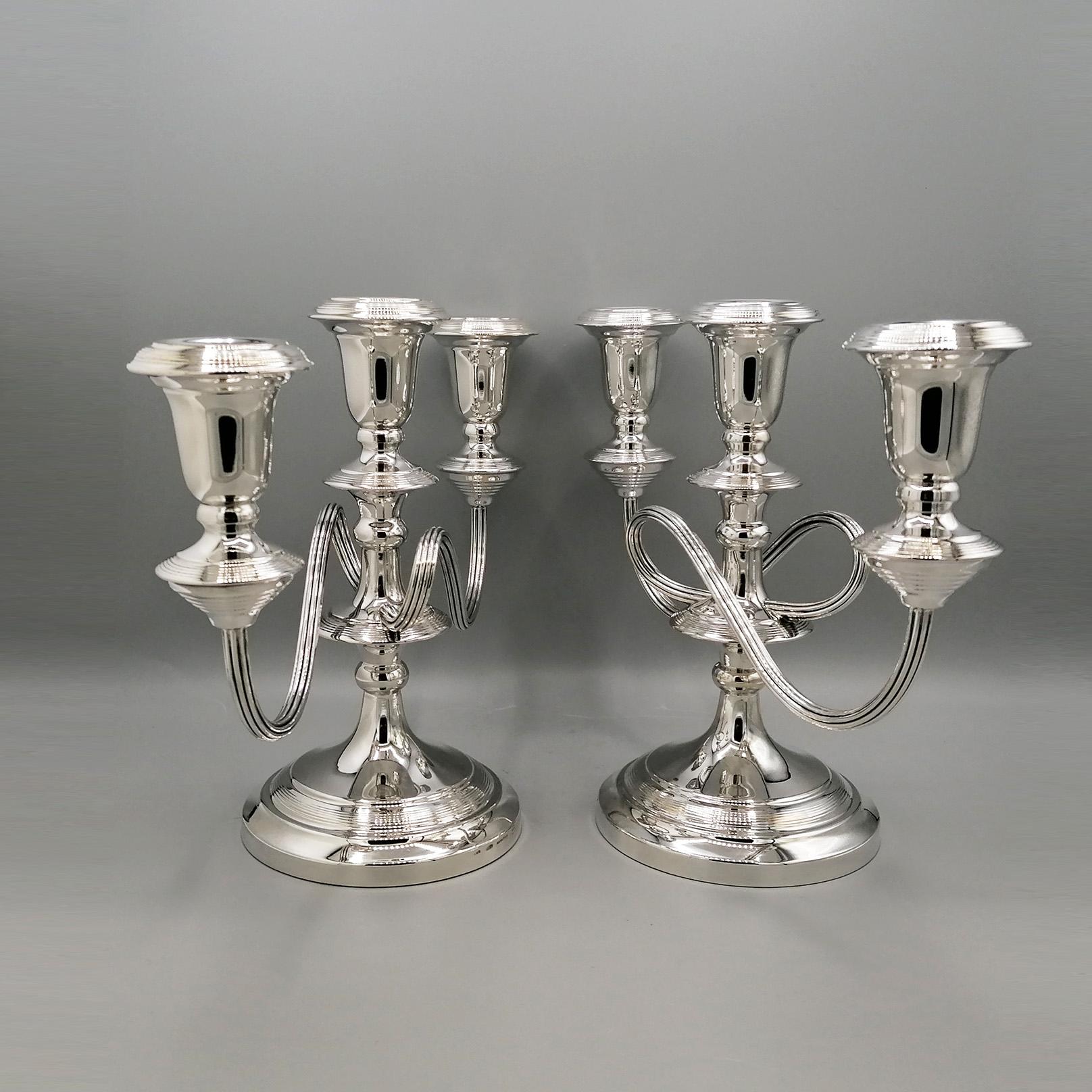 Pair of 3-light candelabra in 800/1000 solid silver.
The base is round decorated with a striped design, which is repeated twice on the stem, in the wax collectors and in the candle holder buds.
The support arms are sinuous with an S design, made