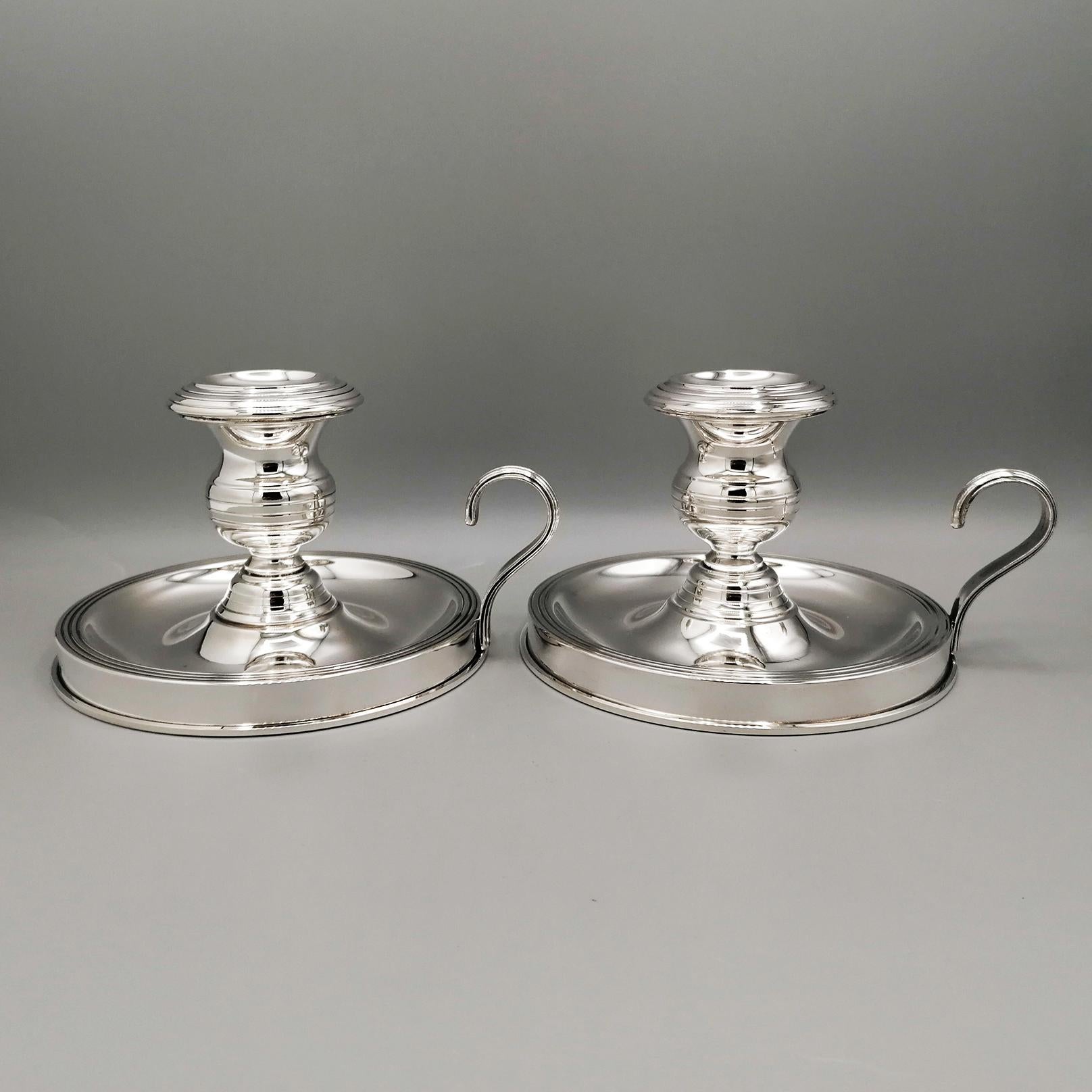 Pair of George III style sterling silver chambersticks.
Round-shaped candlesticks, they are made with a thick silver plate and then grooved both in the lower part of the 