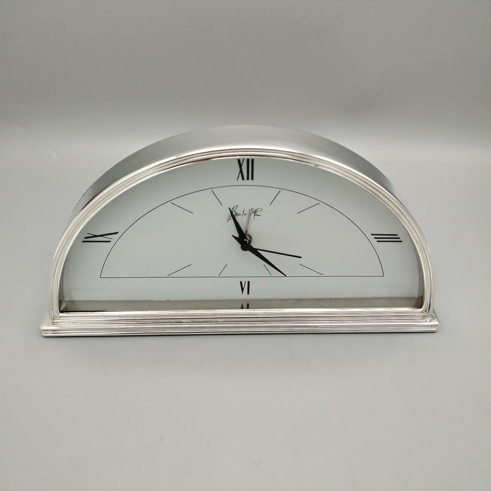 Solid Sterling Silver Art Deco Table Clock.
The shape of the clock is a crescent moon completely smooth except for the base and the frame which are double line made with the casting technique to ensure its weight and stability.
The clock movement is