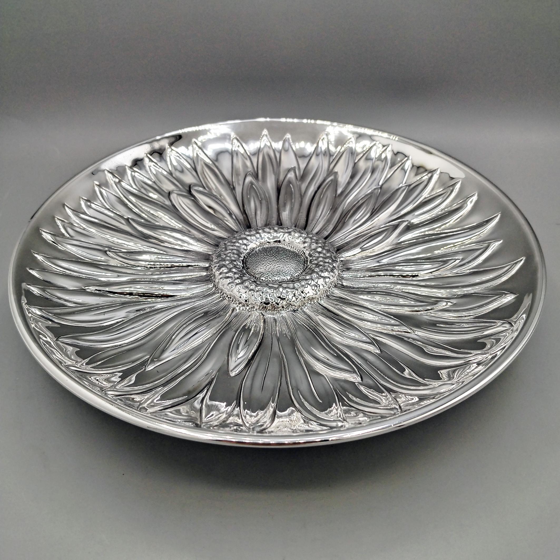 Runde Schale aus Sterlingsilber mit glattem Boden.
Die Schale ist vollständig von Hand ziseliert und mit einem Sonnenblumenmuster versehen. Bemerkenswert ist die Prägung und Ziselierung der Zungenblüten, Scheibenblüten, des Fruchtknotens und der