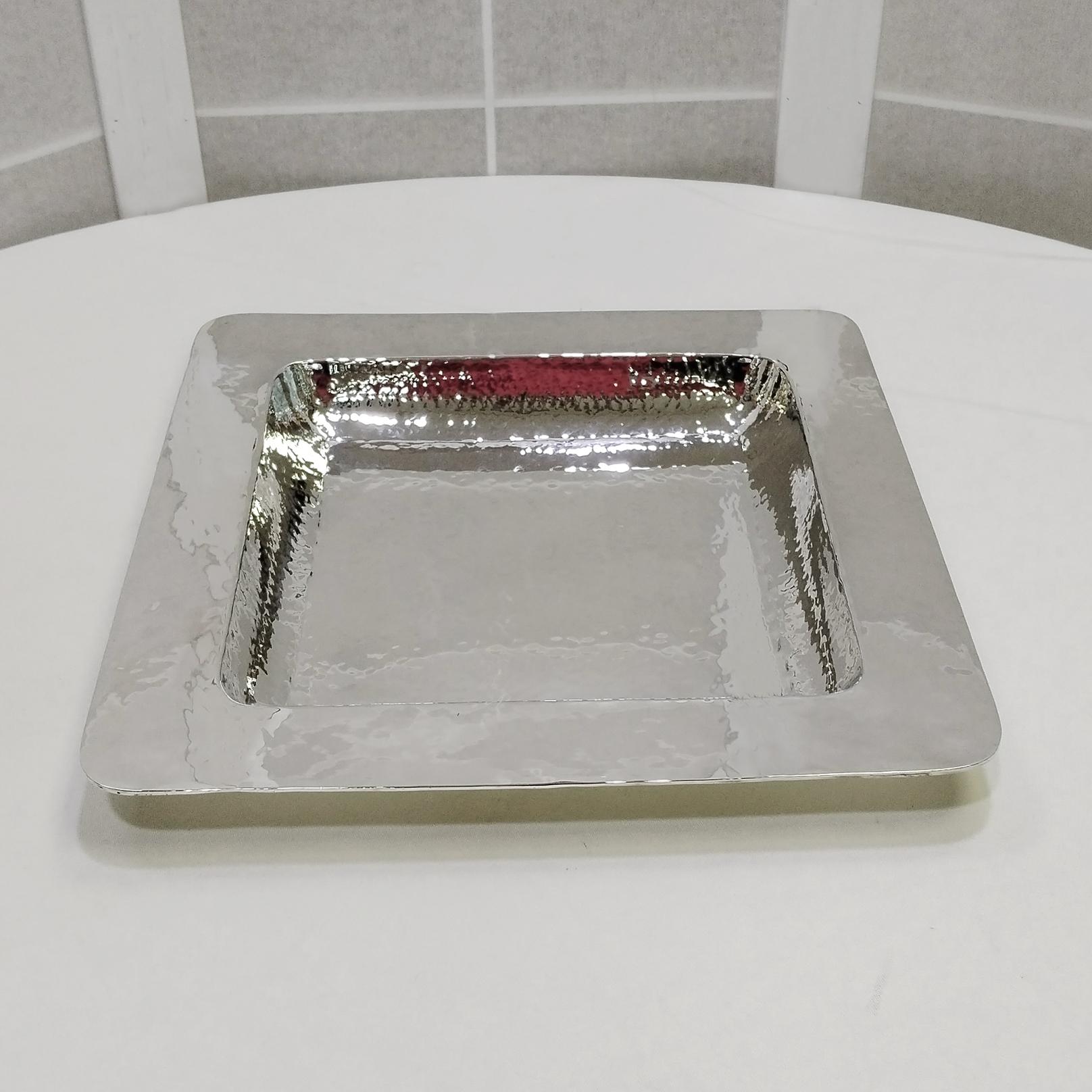 Centro de mesa cuadrado de plata de ley.
El centro de mesa se realizó totalmente a mano a partir de una lámina de plata 925 repujada y martillada hasta obtener un destello muy profundo.
A continuación, la pieza se martilleaba de nuevo para darle un