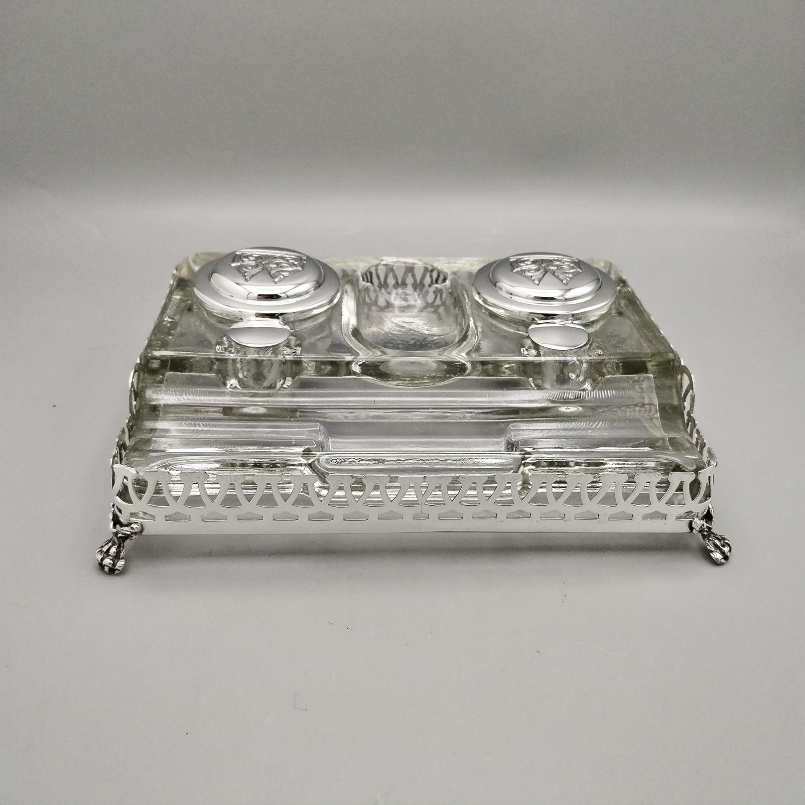 Sterling Silver Inkwell with Fluted Glass Base.
The inkwell is made of glass with various grooves to accommodate pens, nibs, ink etc.
A perforated sterling silver frame supported by feet made with the casting technique depicting lion paws, was
