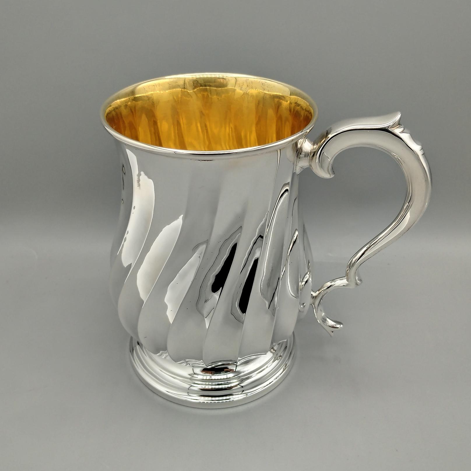 taza de plata maciza 800. El cuerpo de la taza se ha moldeado y redondeado. A continuación, se trabajó con motivos torchon
La base que lo elevaba de la superficie de apoyo es redonda con pequeños escalones.
El mango, fabricado con finas placas de