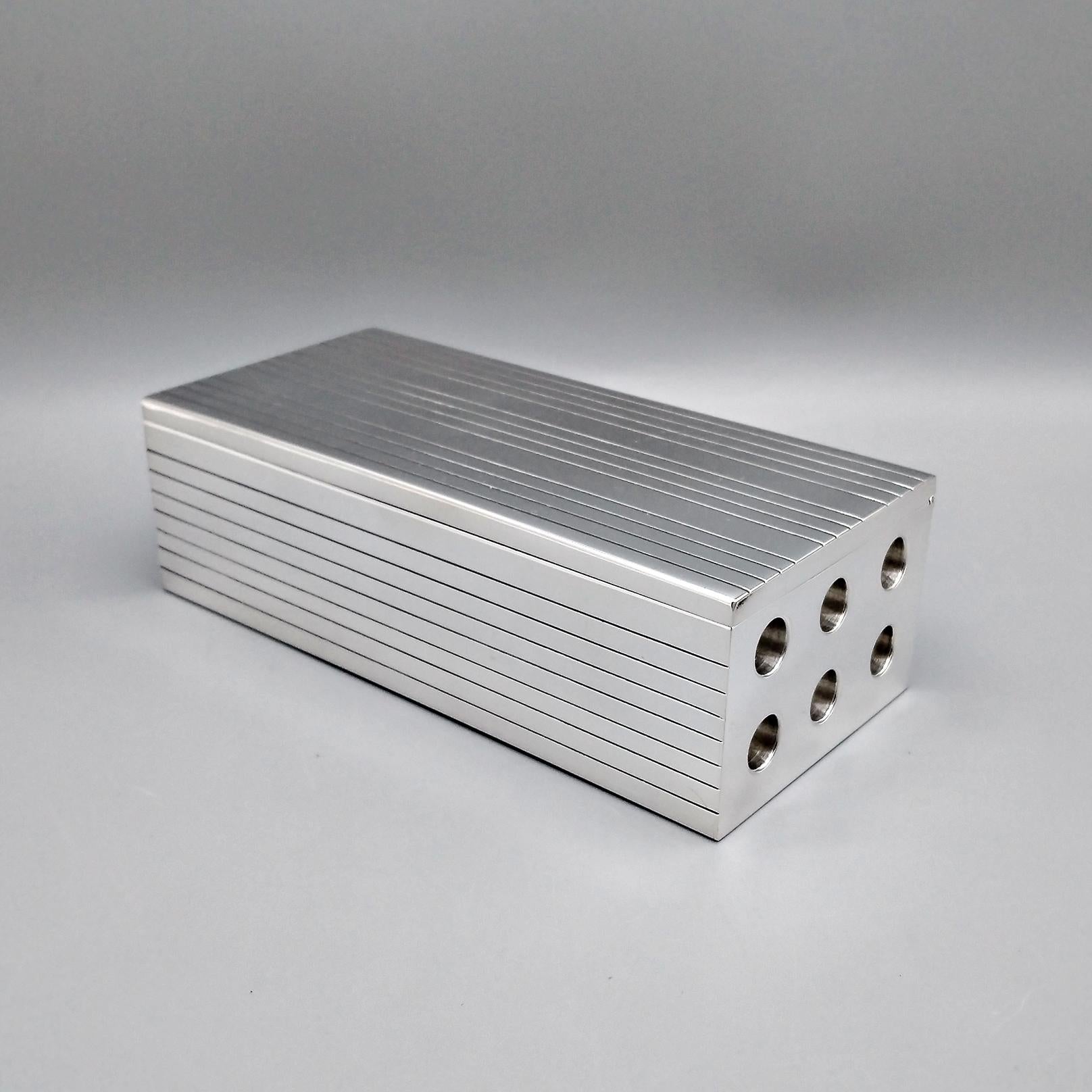 Caja de plata de ley en forma de ladrillo perforado.
La caja se fabricó totalmente a mano a partir de una lámina de plata de ley en bruto y se le dio forma de ladrillo.
Se insertaron casquillos redondos para simular los agujeros laterales de los