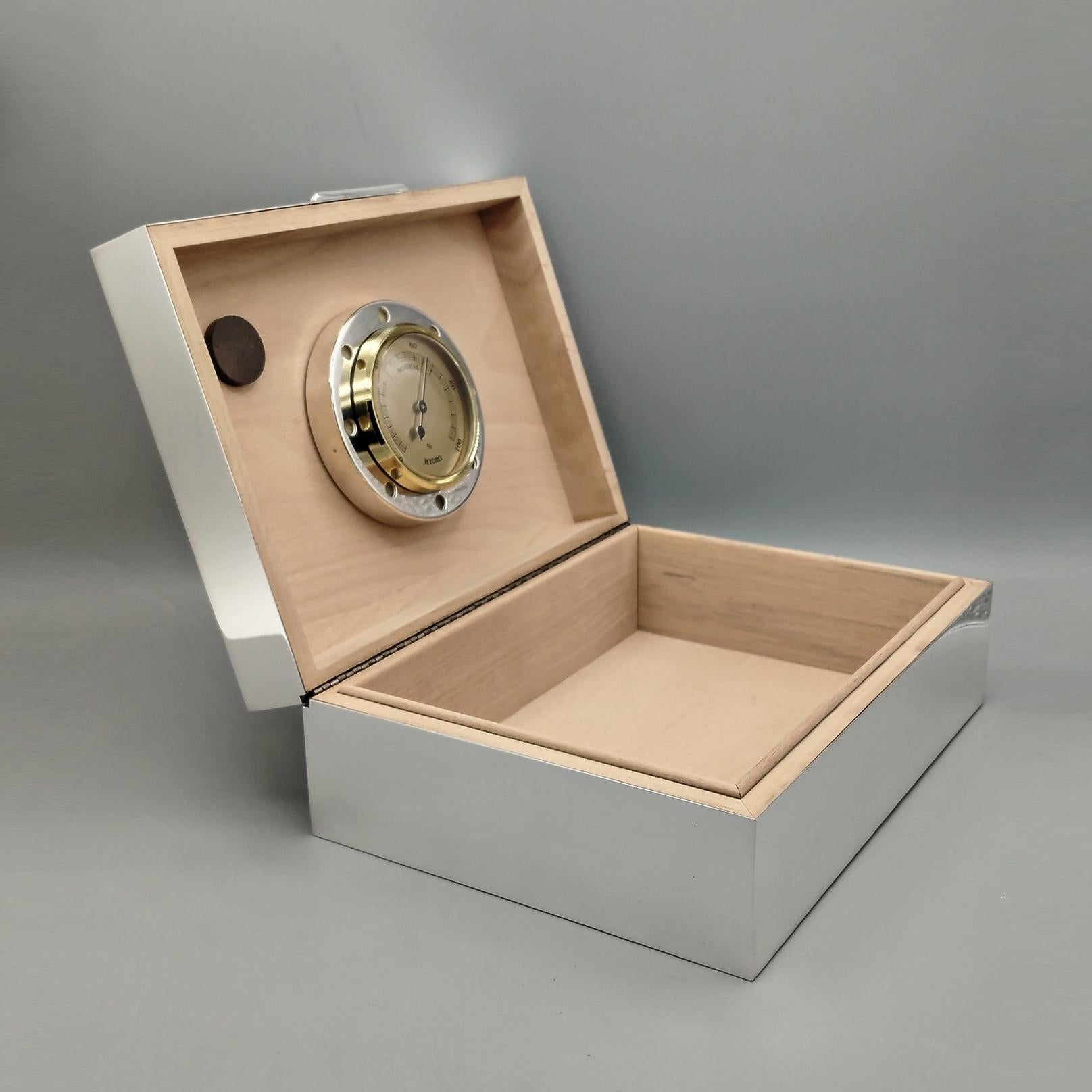 caja de plata de ley 925 para puros.
El cuerpo de la caja es completamente liso con esquinas afiladas.
Un pequeño saliente plateado permite abrir la caja.
El interior de la caja es de madera adecuada para la conservación de puros finos y está