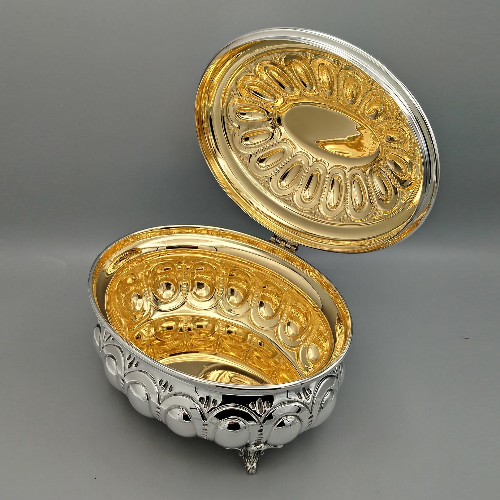 Caja cofre decorativa de plata de ley 925 con interior chapado en oro de 24 quilates.
El cuerpo de la caja está repujado y cincelado con un diseño de óvalos, al igual que la tapa abisagrada.
Se ha dejado una parte lisa en el centro de la tapa para