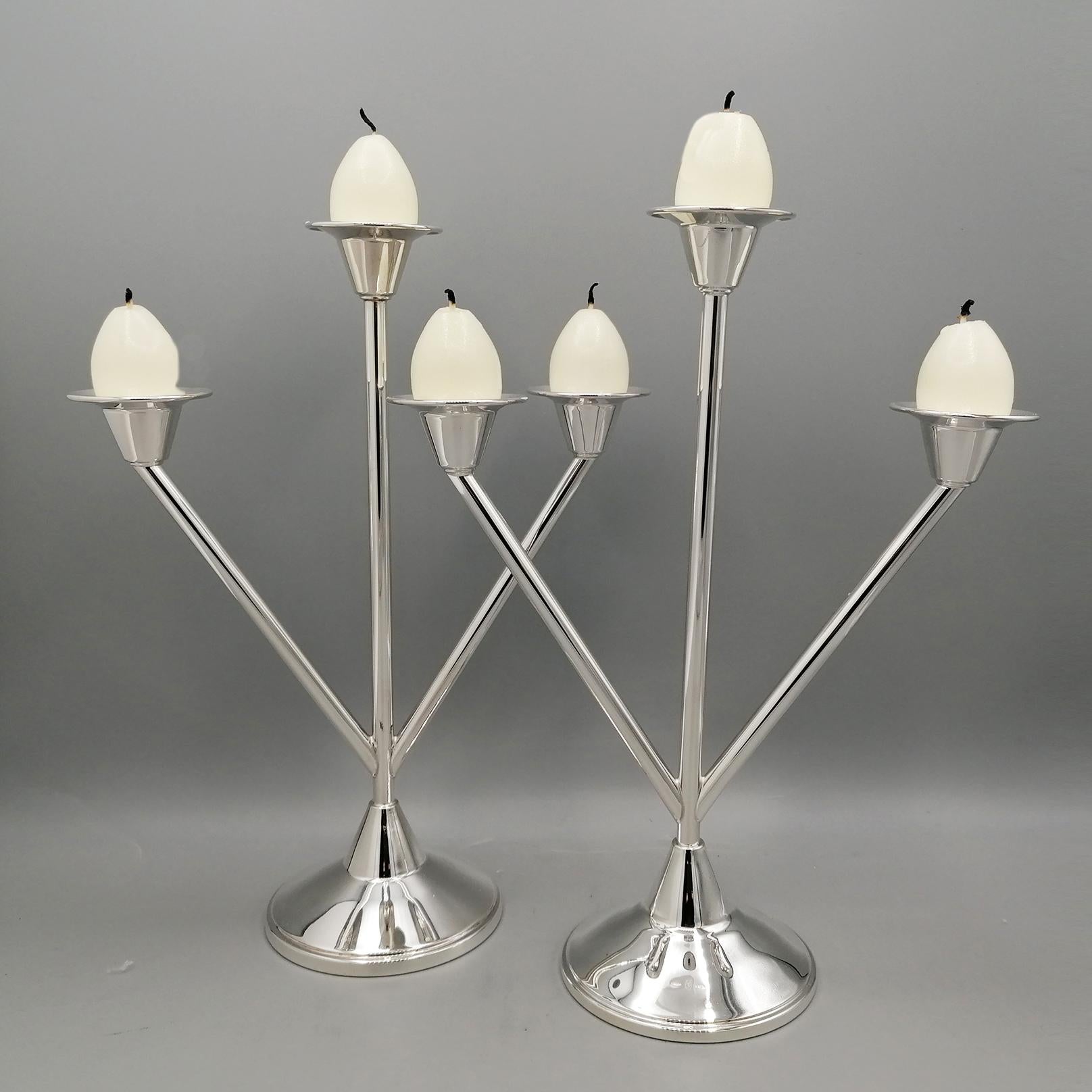 Pair of solid silver candlesticks in Art Deco style.
The base is round where 3 canulae have been welded which represent the candlestick branches.
The central cannula is larger than the other 2.
The wax collectors are round and smooth as are the
