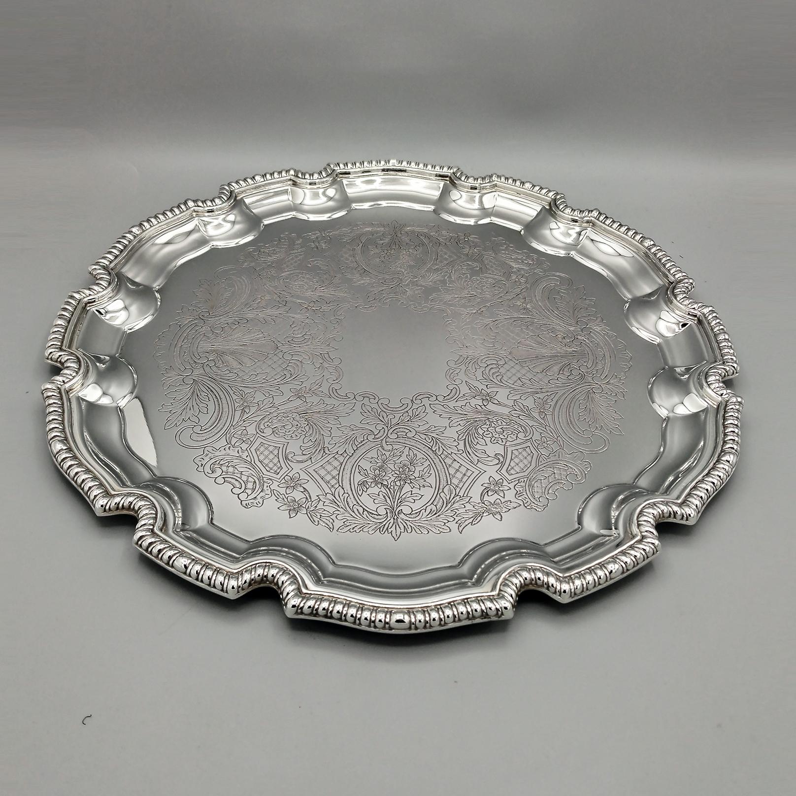Round tray shaped in baroque style.
The tray is round with a shaped edge. A cord border has been welded on the outermost part.
Inside the tray a design with scrolls and flowers, typical of the baroque style, has been engraved by hand.
The center of