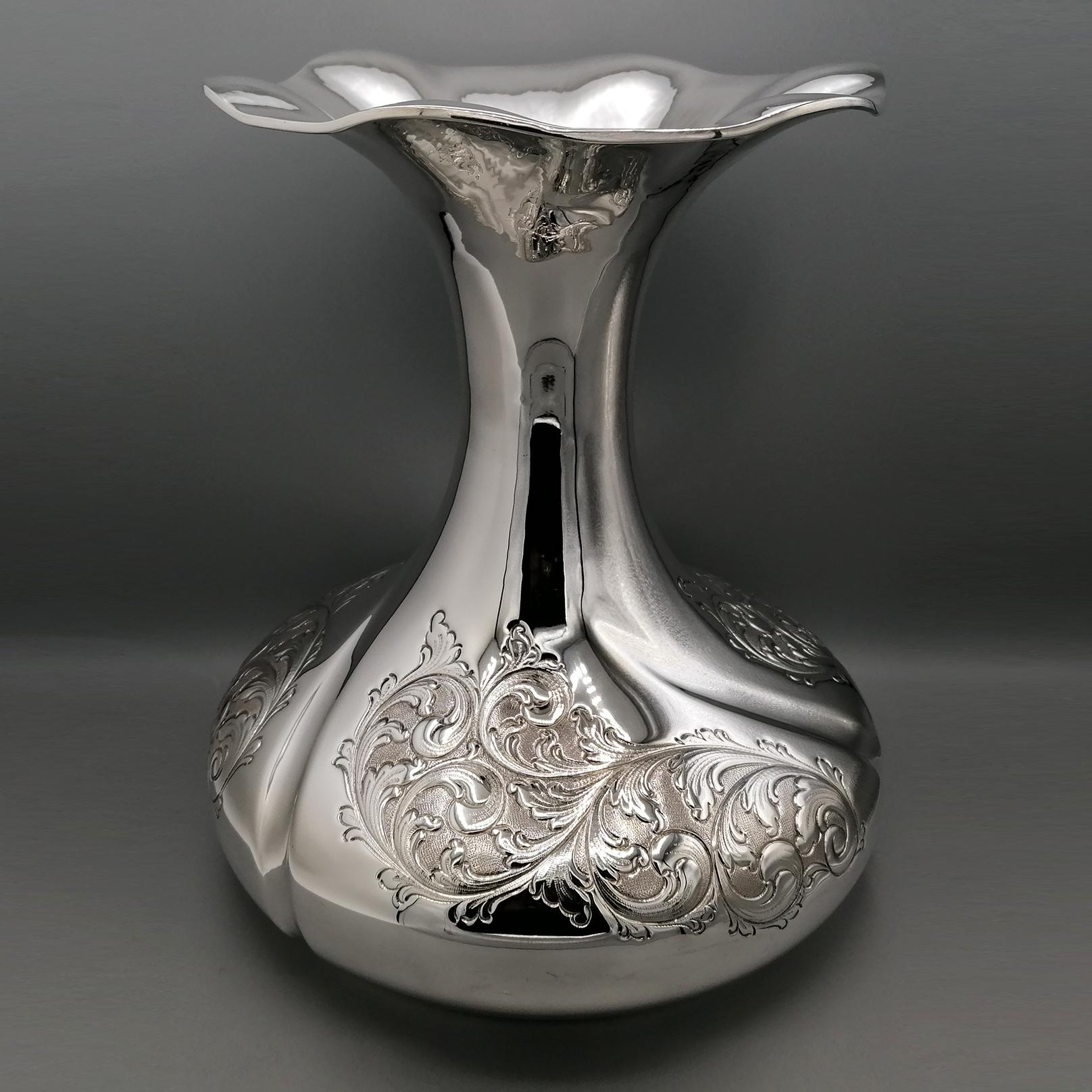Grand vase en argent massif.
De grandes dimensions, ce vase a été réalisé entièrement à la main dans un style baroque revisité.
La base est très large et présente des gaufrages et des gravures à la main qui reproduisent les volutes typiques du style