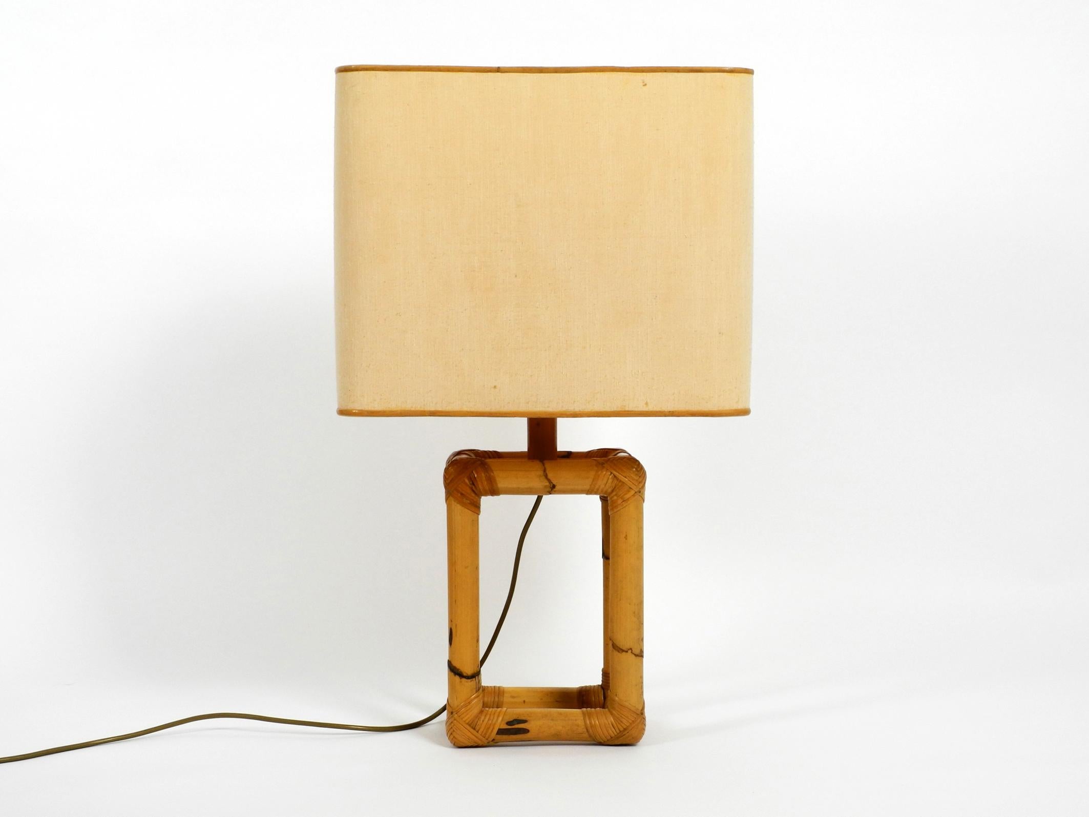 Extra large 1960s Minimalist bamboo table lamp with a large fabric shade.
Beautiful design from the 1960s. Presumably from an Italian production.
Frame made entirely of thick bamboo wood and bound with bamboo raffia.
Very good vintage condition
