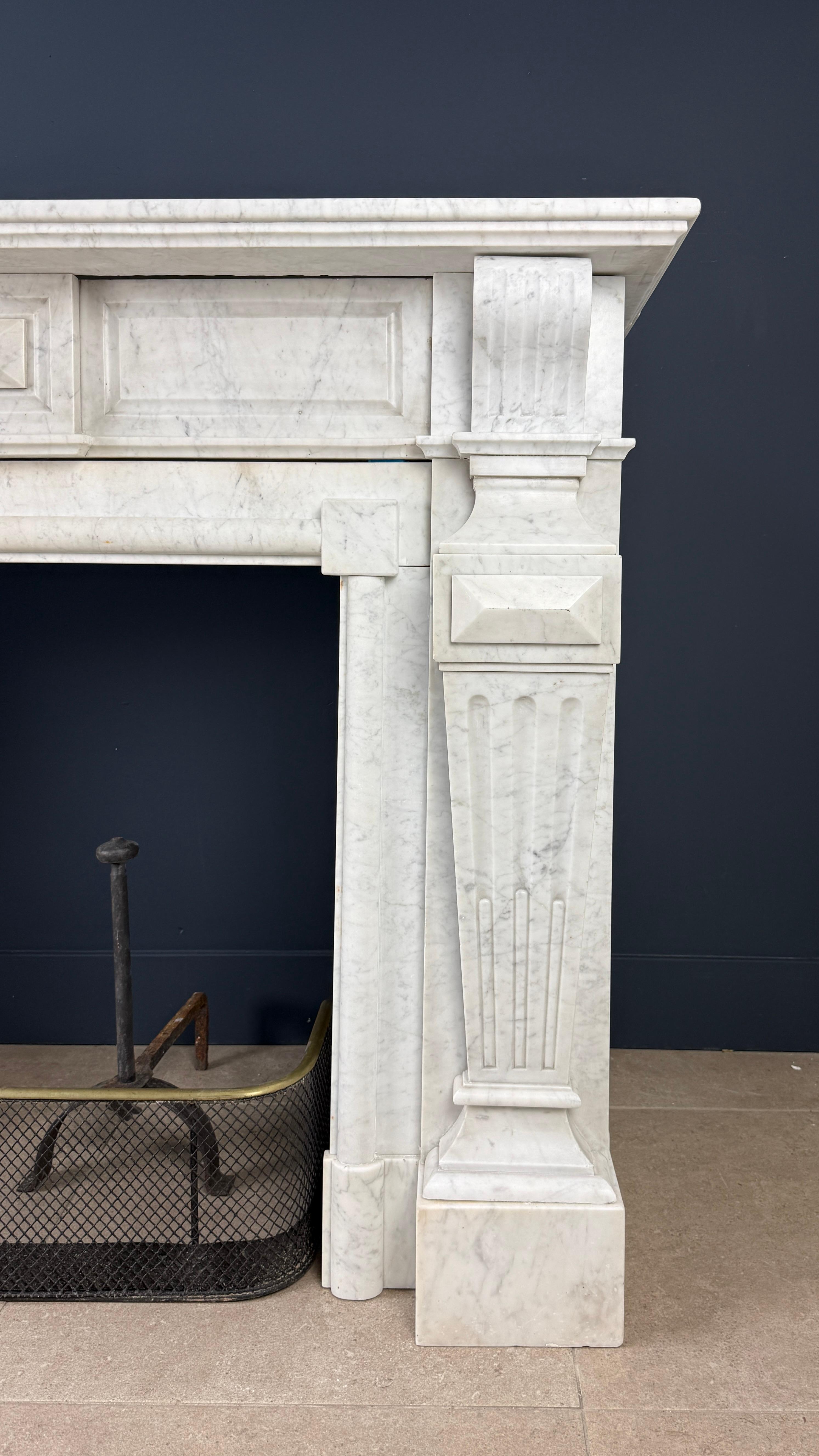 Revestimiento antiguo de tamaño real en mármol blanco de Carrara. Esta singular repisa de gran tamaño tiene un marcado aspecto imperial.
Las majestuosas consolas están marcadamente revestidas, lo que confiere a esta repisa envolvente un aspecto