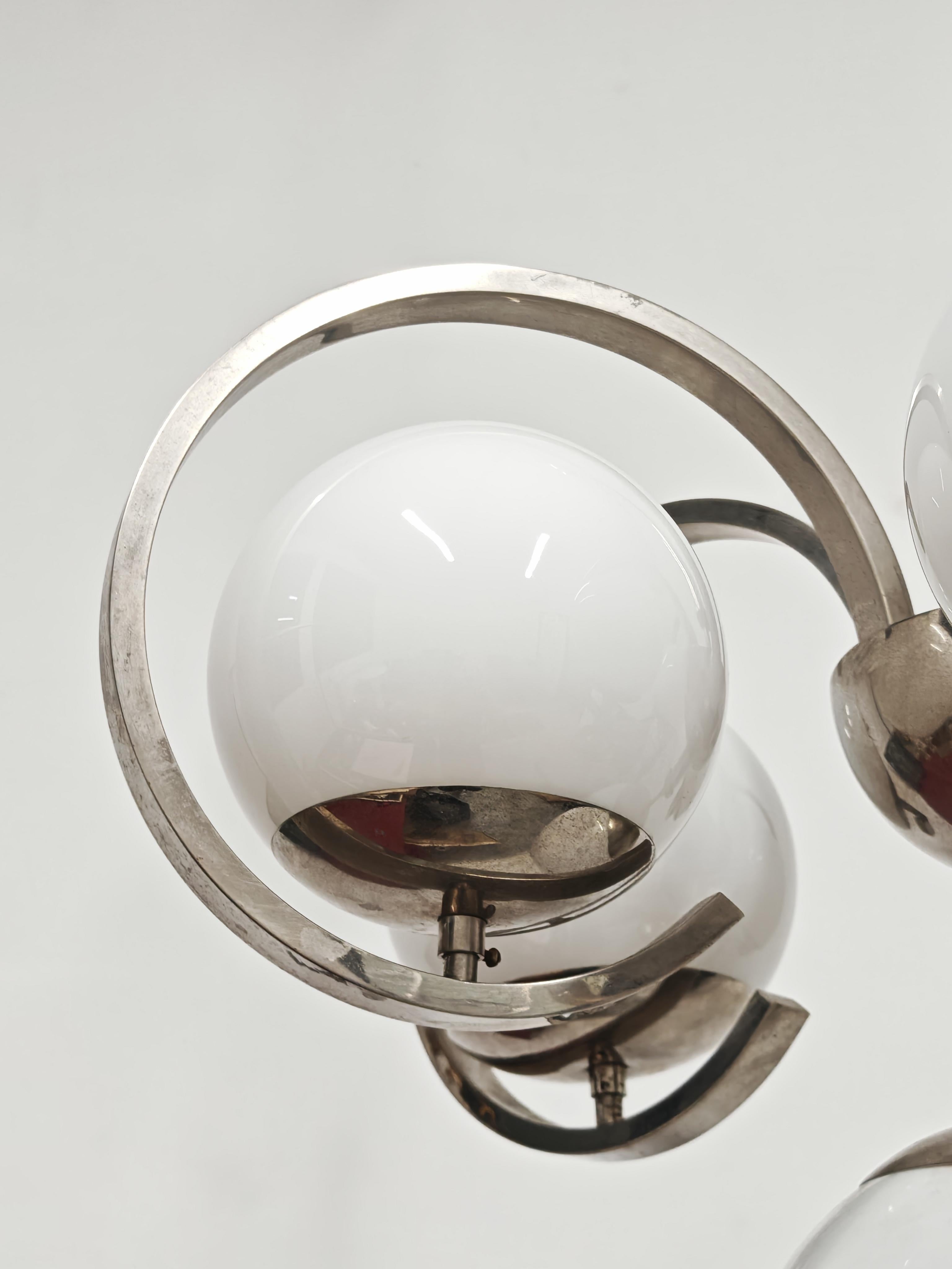 Vous trouverez dans cette annonce un superbe lustre Bauhaus XXL en laiton nickelé, avec 6 abat-jours en verre au lait. Le design est caractéristique des mouvements Art Deco et Bauhaus, connus pour leurs formes géométriques, leurs lignes audacieuses