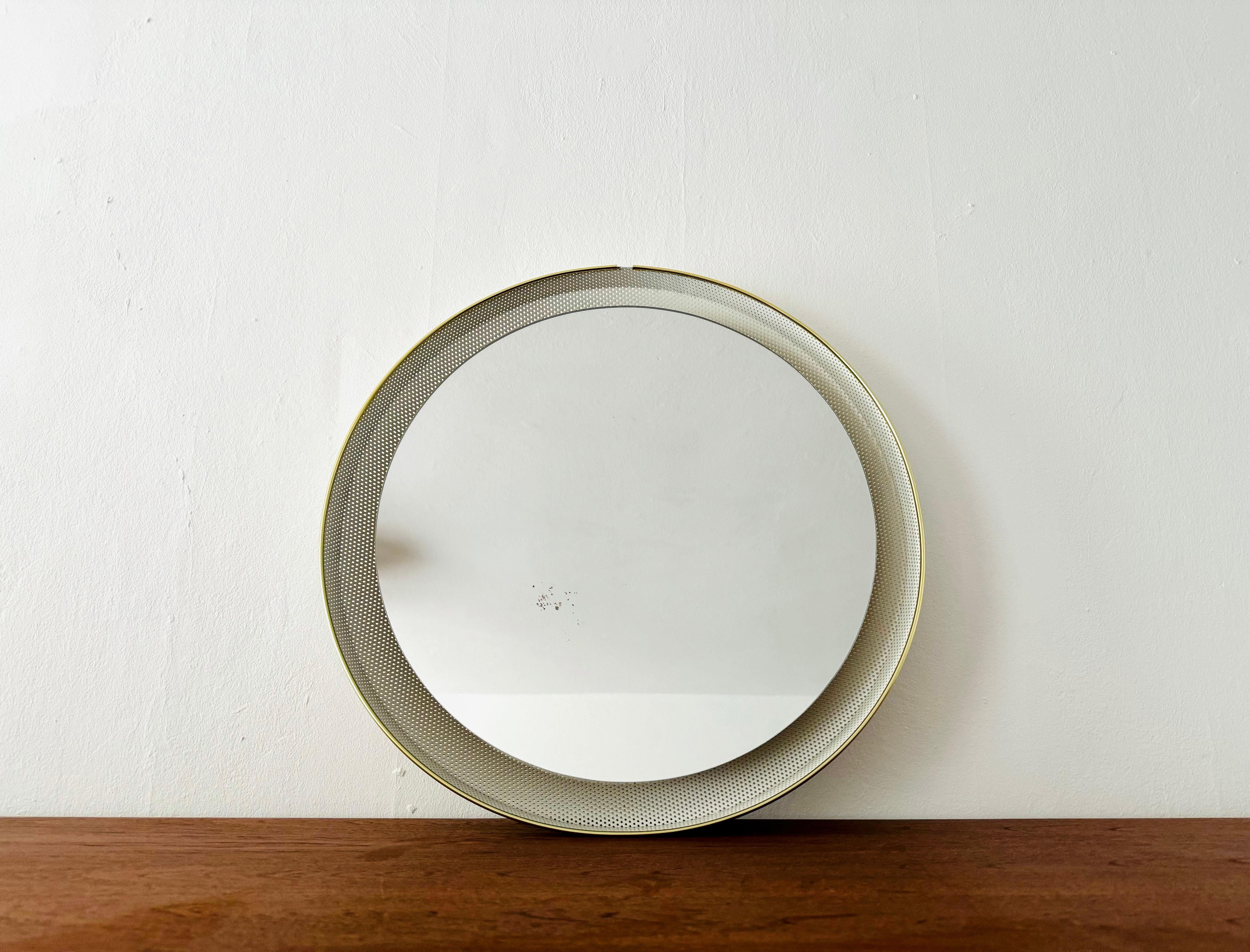 Very nice illuminated wall mirror from the 1950s.
Very elegant and classic shape.
The holes in the edge create a spectacular play of light.

Design: Ernest Igl
Manufacturer: Hillebrand

Condition:

Very good vintage condition with slight signs of