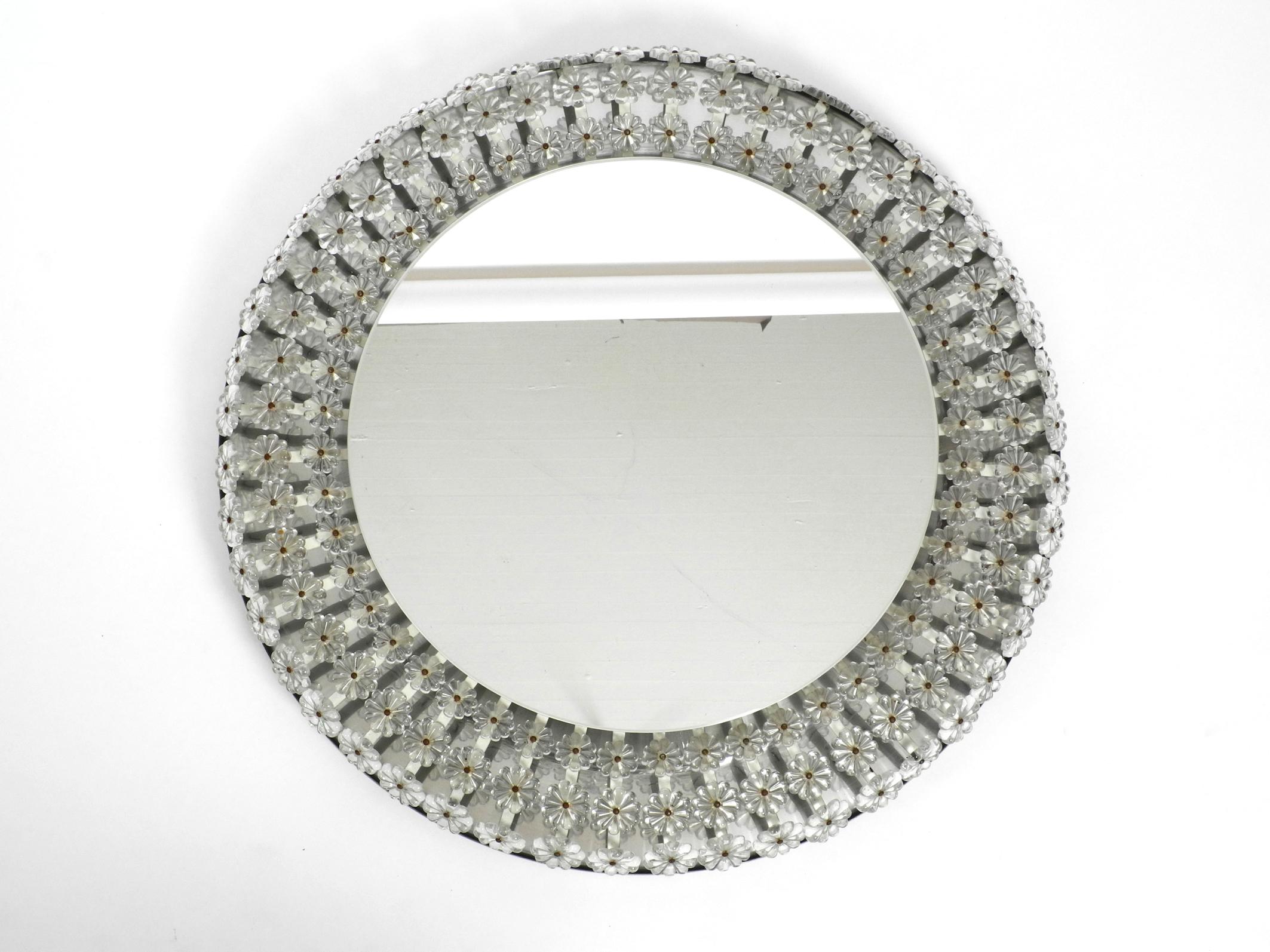 Beautiful round large Mid-Century Modern illuminated wall mirror by Schöninger. Made in Germany.
Great elaborate design with lots of real glass stones in the shape of flower blossoms.
Back is made of aluminum with eight original E14 sockets for