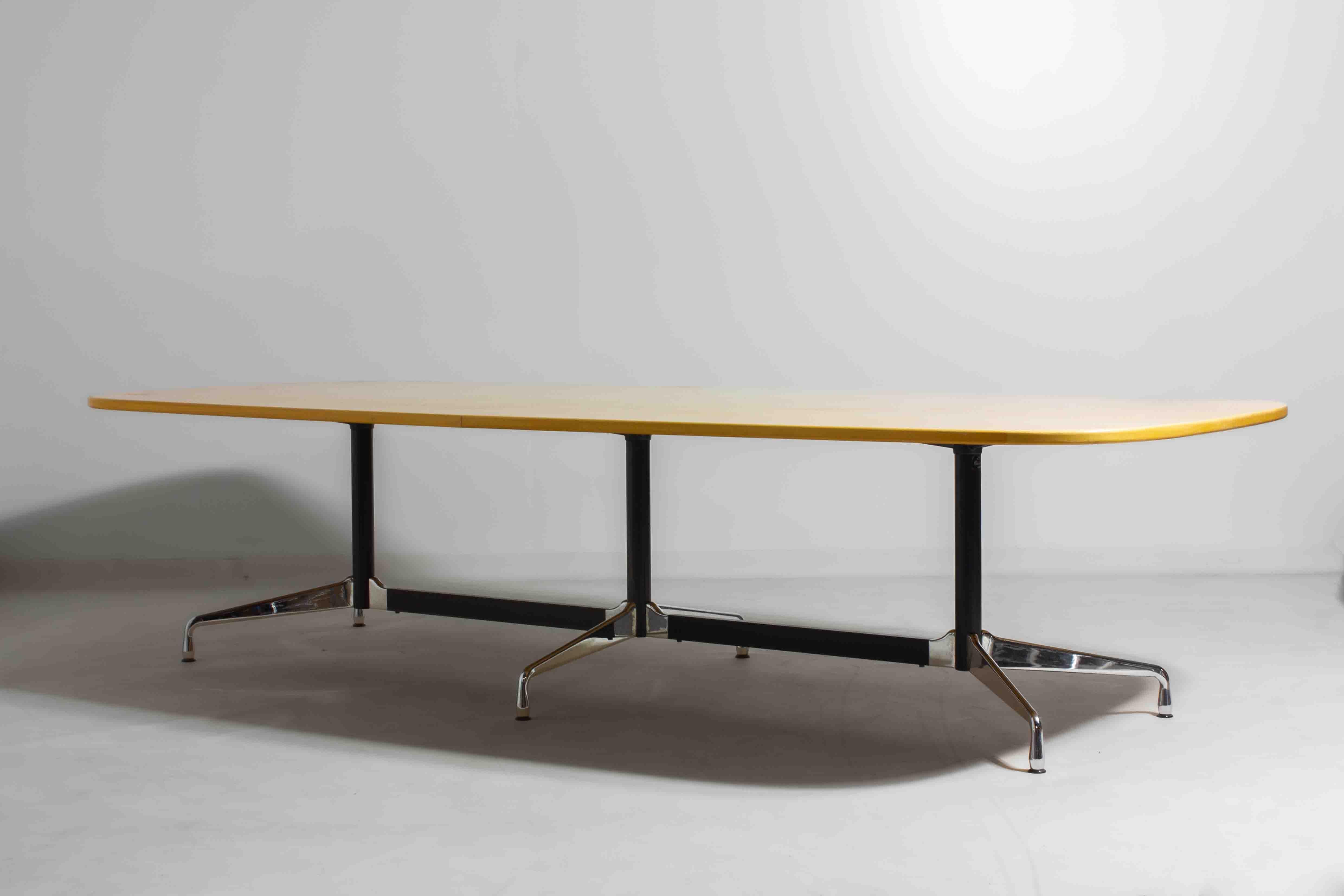 Large conference table designed by Charles and Ray Eames, produced by Vitra in 2003. The 320 cm top is finished in light, qualitative oak veneer with softly rounded corners. The table rests on a segmented black steel beam and stands on three