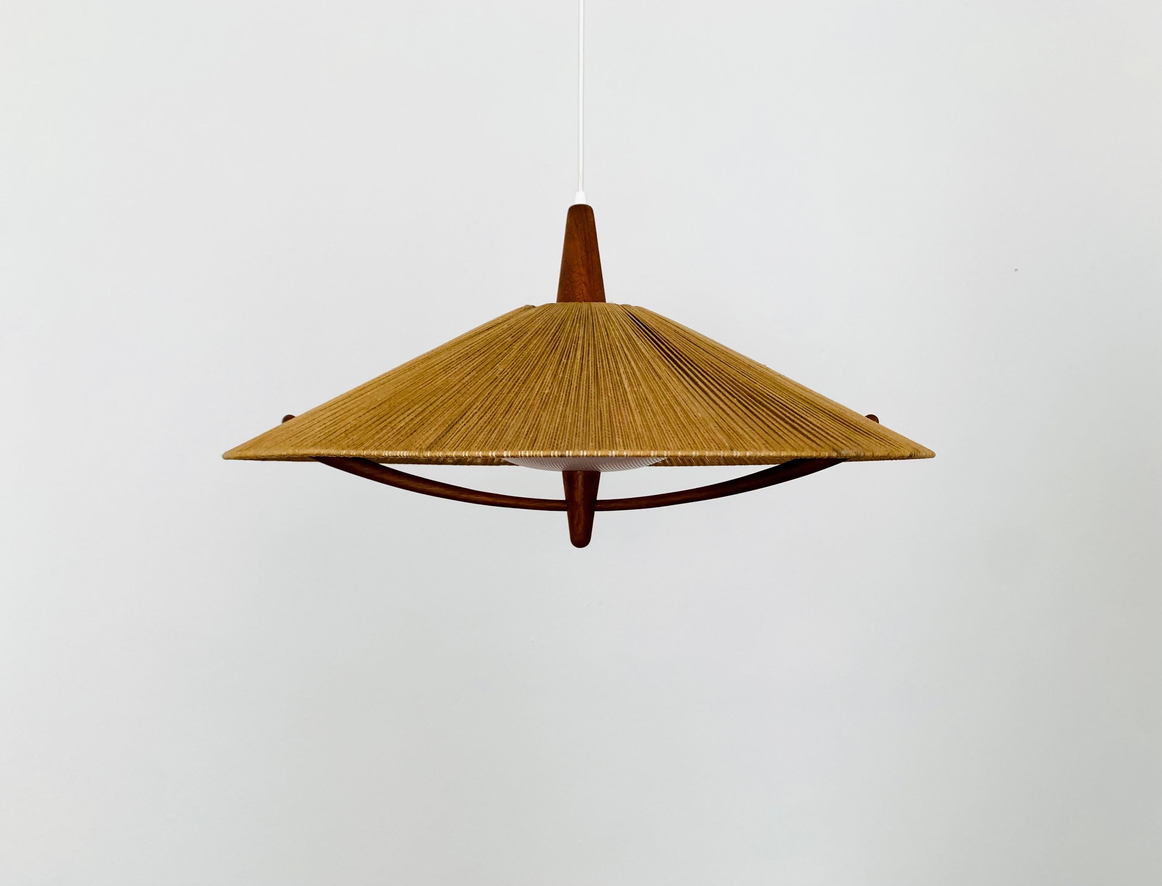 Exceptionally beautiful and very large pendant light from the 1960s.
The design is very unusual.
The shape and the materials create a warm and very pleasant light.
The teak details are beautifully shaped.

Condition:

Good vintage condition