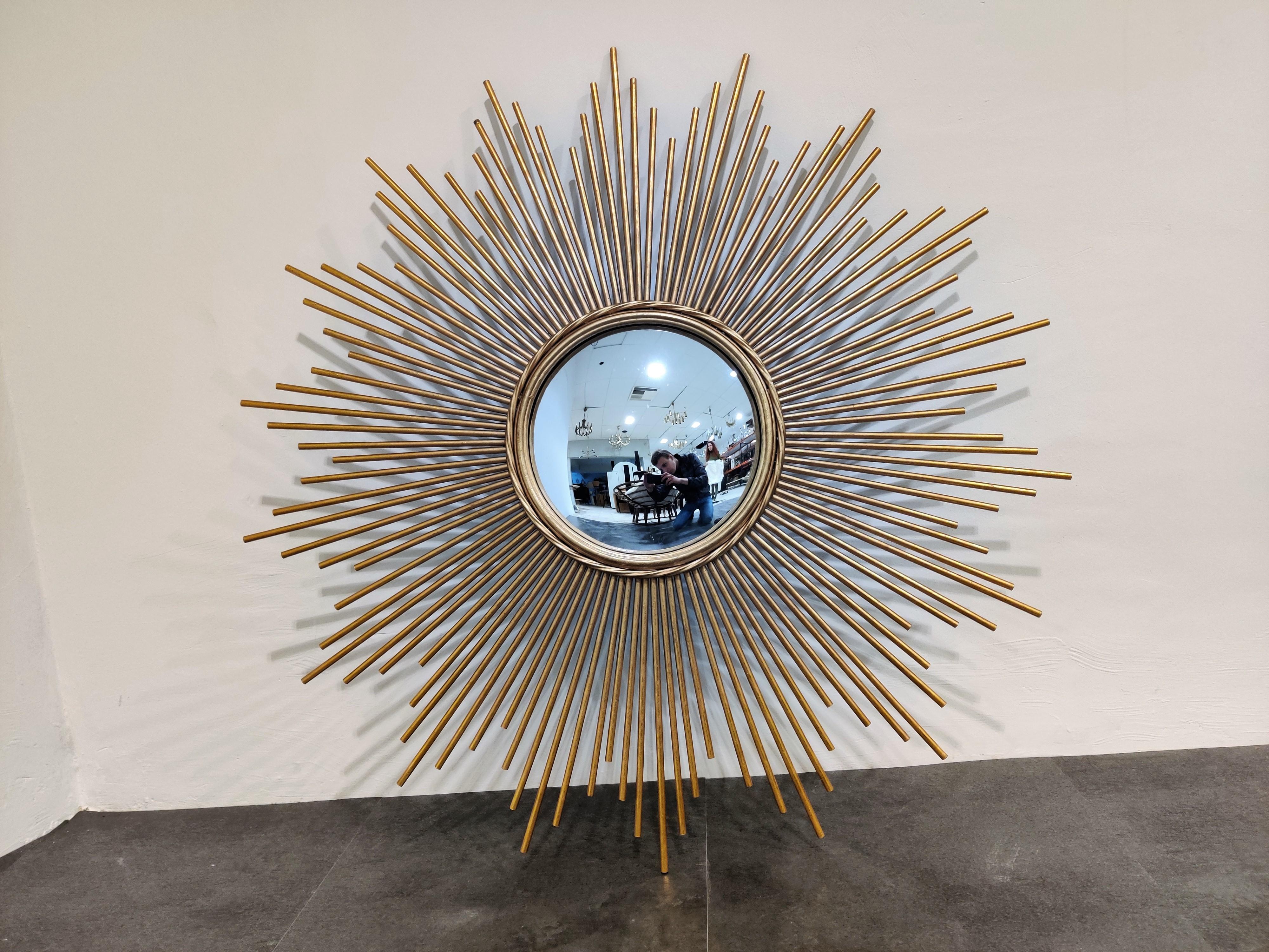 Impressive gilt metal sunburst mirror with tubular meatal sunrays.

The large scale is wat really makes this piece stand out.

Very good condition.

France - 1960s

Measures: Diameter frame 98cm/38.58