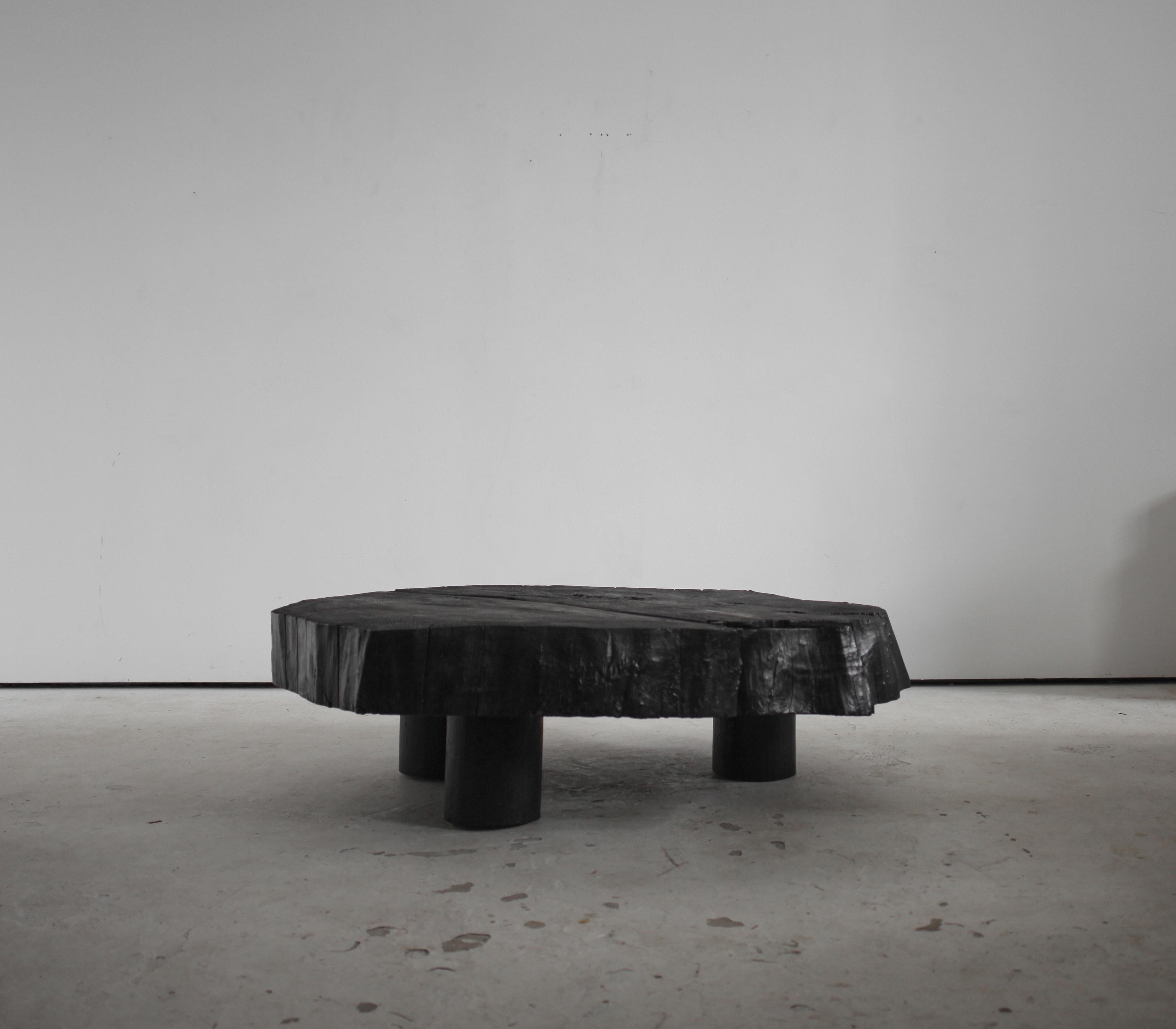 An XXL gnarly charred chestnut coffee table on three circular charred elm feet.

Reminiscent of the work of Caldas.

16.5cm thick top. 