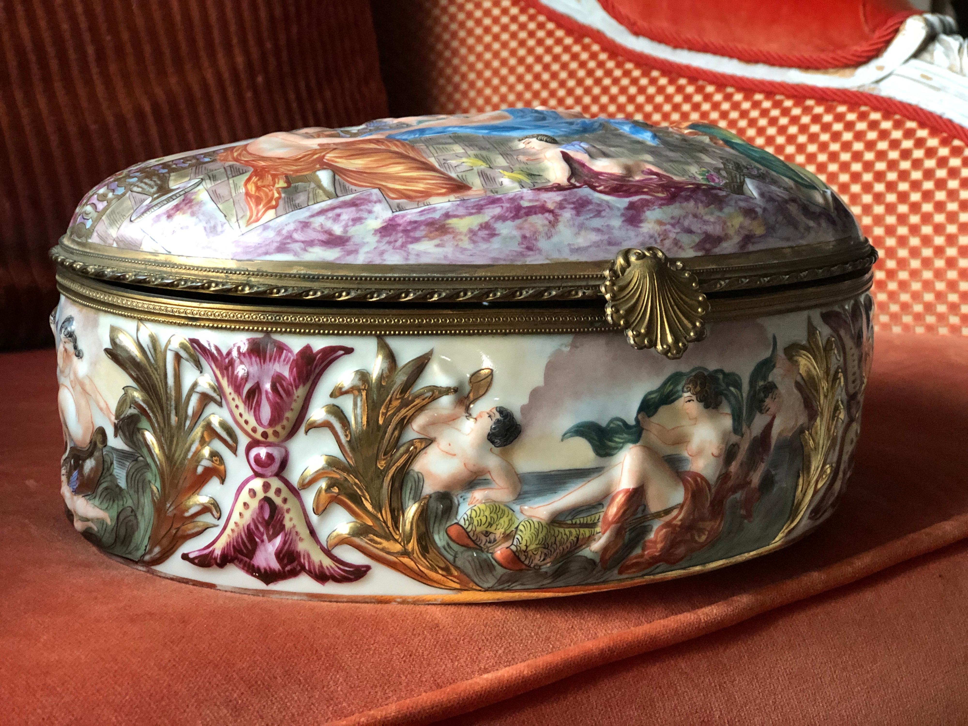Boîte en porcelaine ancienne Capodimonte richement décorée de figures en relief peintes en couleur tout autour de la pièce et de petites peintures florales à l'intérieur de la boîte. Très bon état, sans restaurations. 
Italie, vers 1920.
 