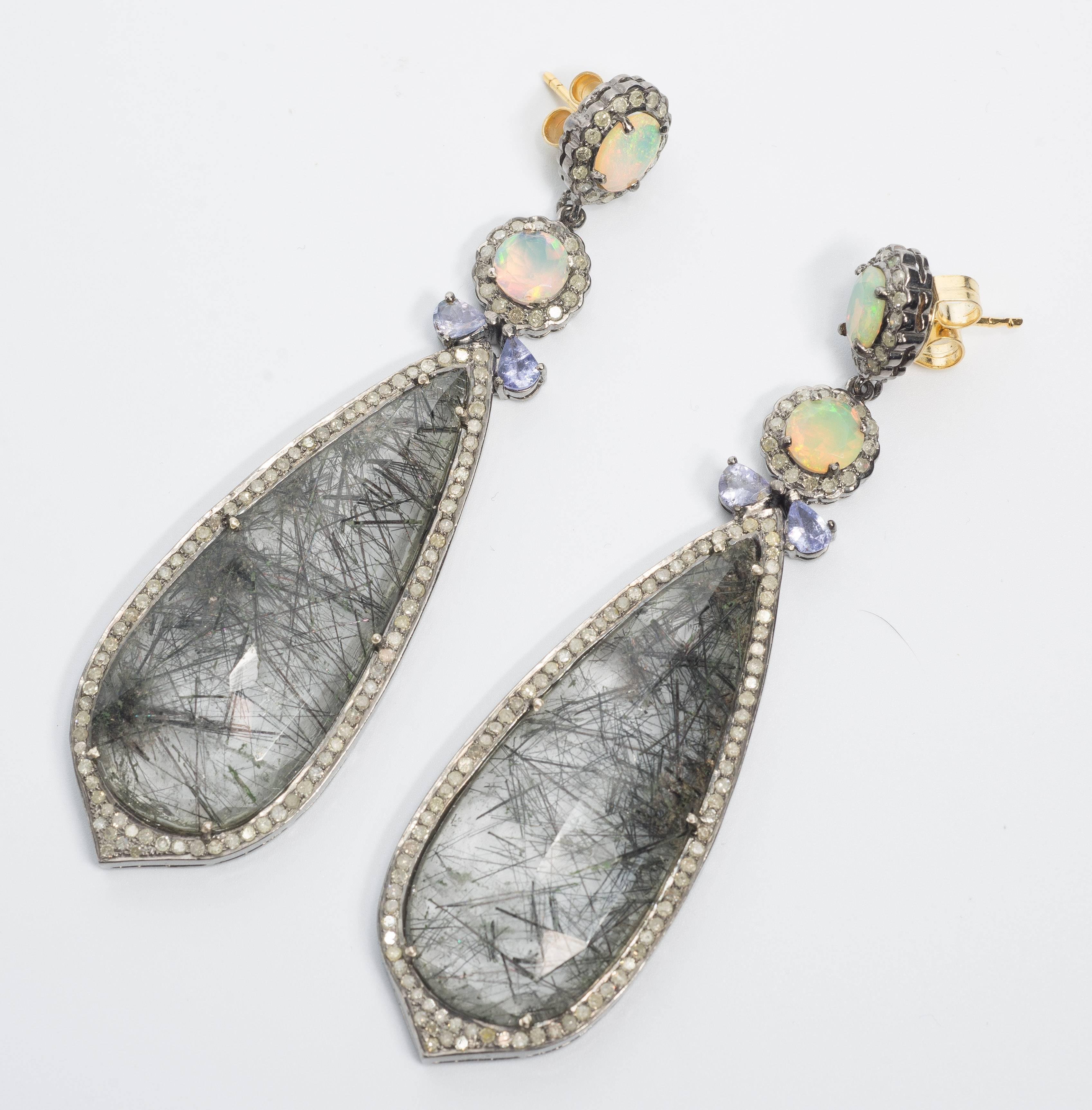 Stunning Fine Quality Diamond Opal Rutilated Needle Quartz Long Earrings measuring 3.5 inches long by 1 inch wide.
The rutilated quartz has strong black needles, is thick with complete faceted tops delicately set with antique cut diamonds and topped