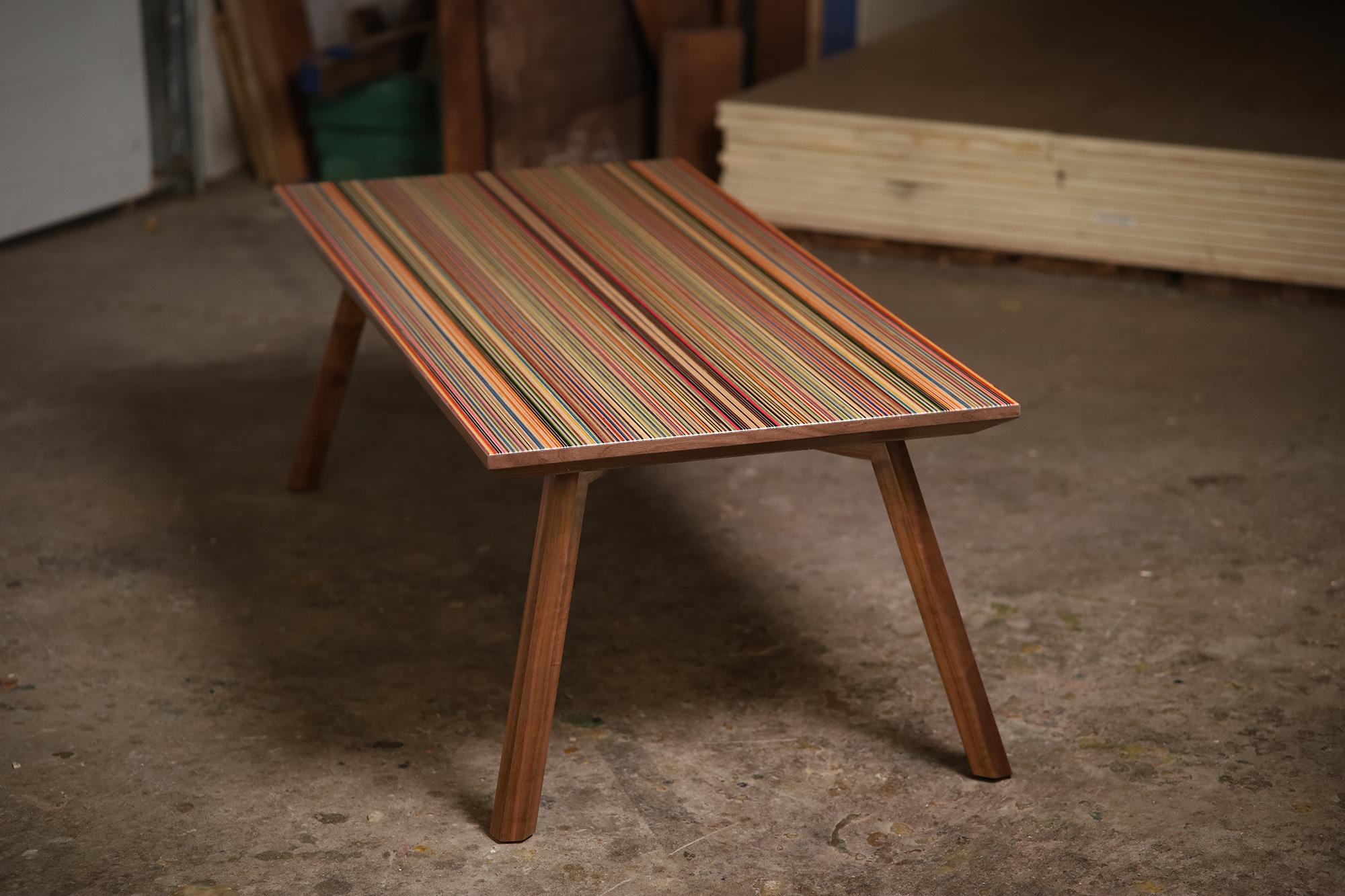 This updated version of our mid-century modern inspired coffee table showcases a vibrant recycled skateboard top adorned with refined edge details, paired with robust splayed solid walnut or sapele hexagonal legs
The legs are easily assembled with
