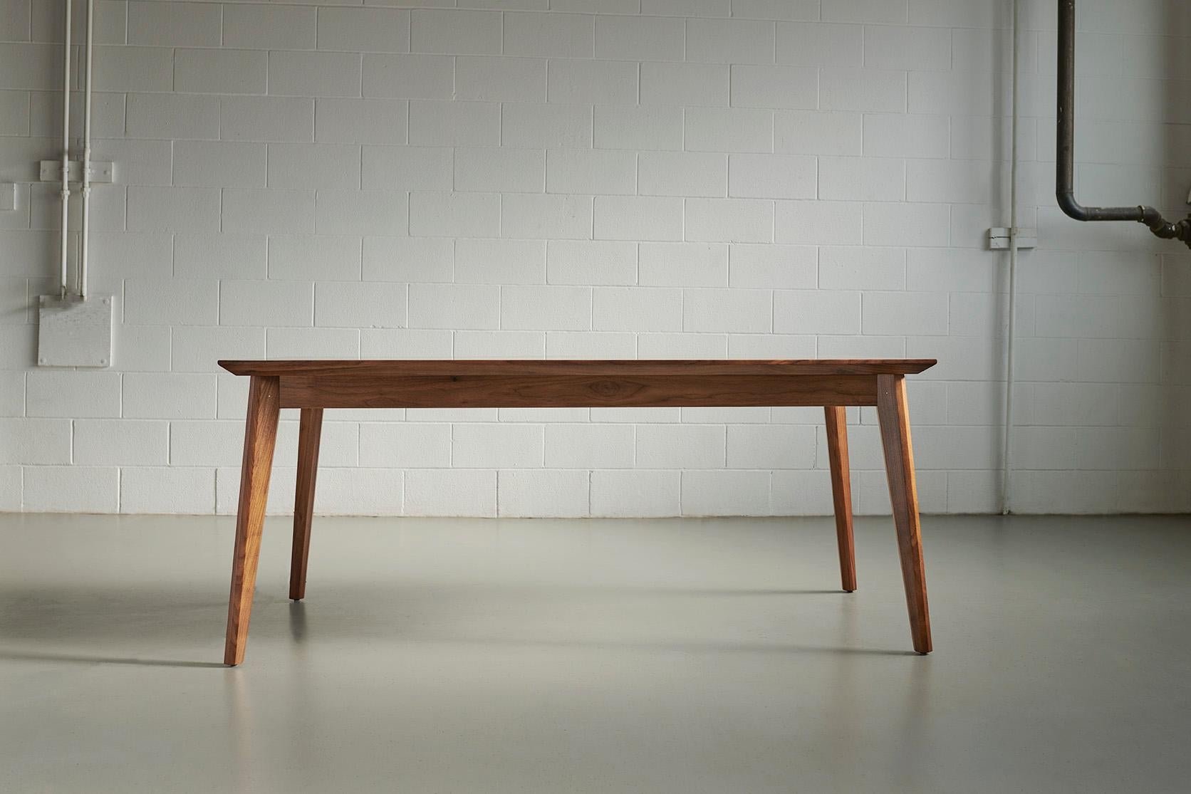 Cette table de salle à manger combine un vibrant motif de planche à roulettes en forme d'étoile avec des garnitures et des pieds en noyer massif, mettant en valeur une version contemporaine du design moderne du milieu du siècle dernier. Ses élégants