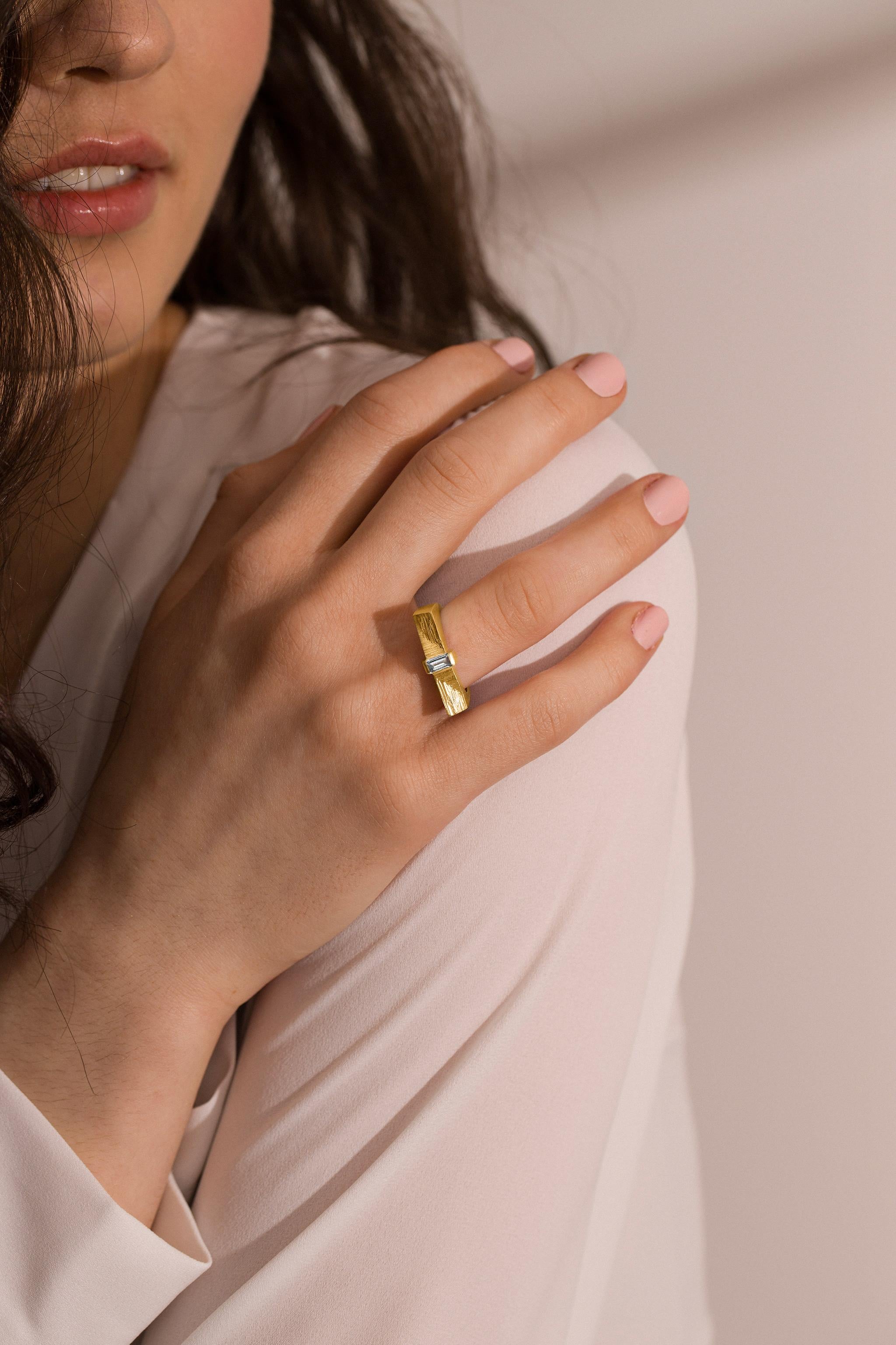 Dove la precisione architettonica incontra la poesia minerale, questa creazione in oro 18 carati sospende un luminoso diamante baguette tra superfici intagliate a mano che richiamano la cristallizzazione naturale della pirite.

La silhouette