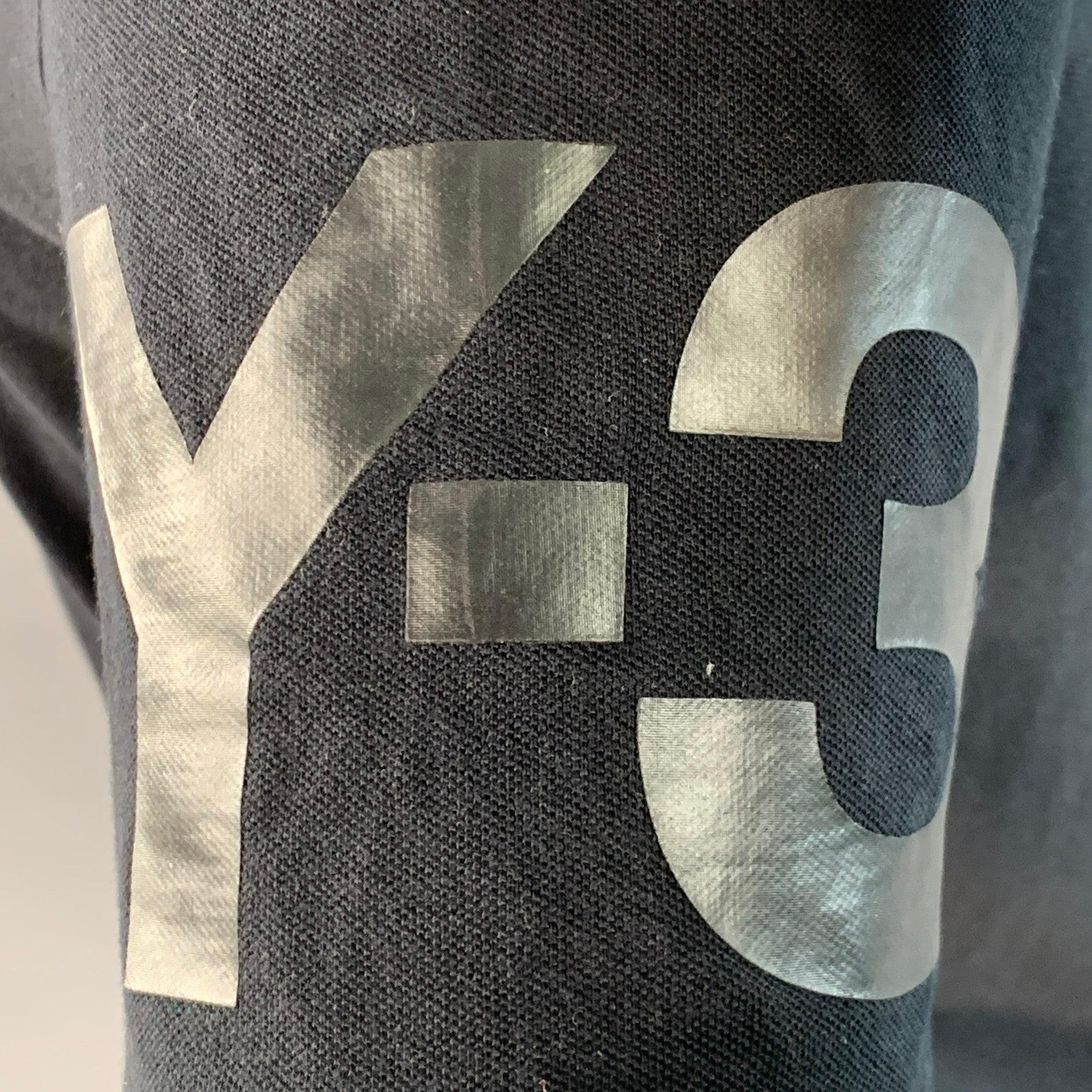Polo Y-3 in piqué di cotone nero con stampa del logo Y-3 in tono sulla manica e chiusura a mezzo bottone. Eccellente condizione di usato. 

Contrassegnato:   M 

Misure: 
 
Spalla: 16,25 pollici Petto: 41 pollici Manica: 9,25 pollici Lunghezza: 29