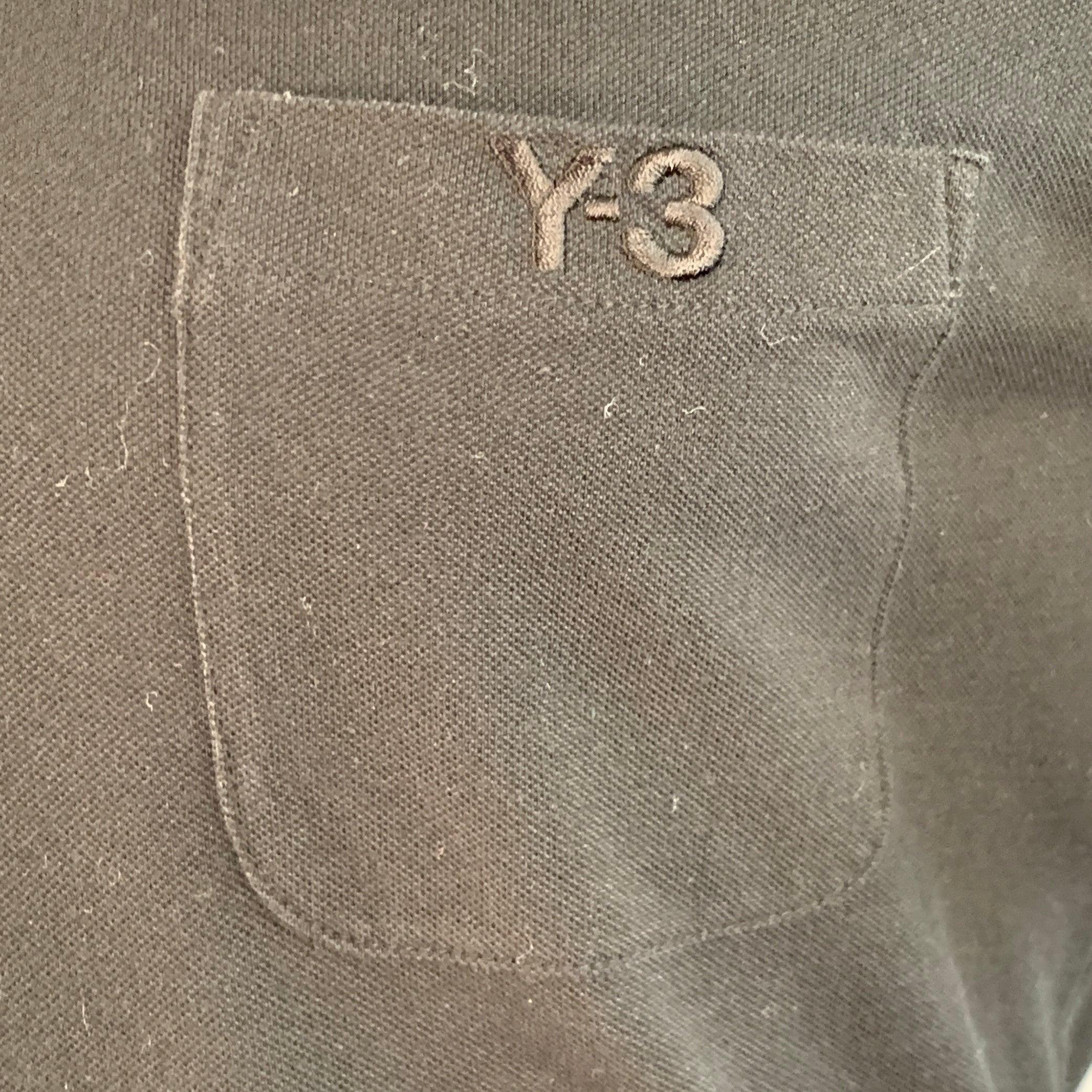 Polo Y-3 in piqué di cotone nero con una tasca con logo Y-3 ricamato e chiusura a mezzo bottone. Eccellente condizione di usato. 

Contrassegnato:   M 

Misure: 
 
Spalla: 16,5 pollici Petto: 39 pollici Manica: 8,5 pollici Lunghezza: 26 pollici 

 