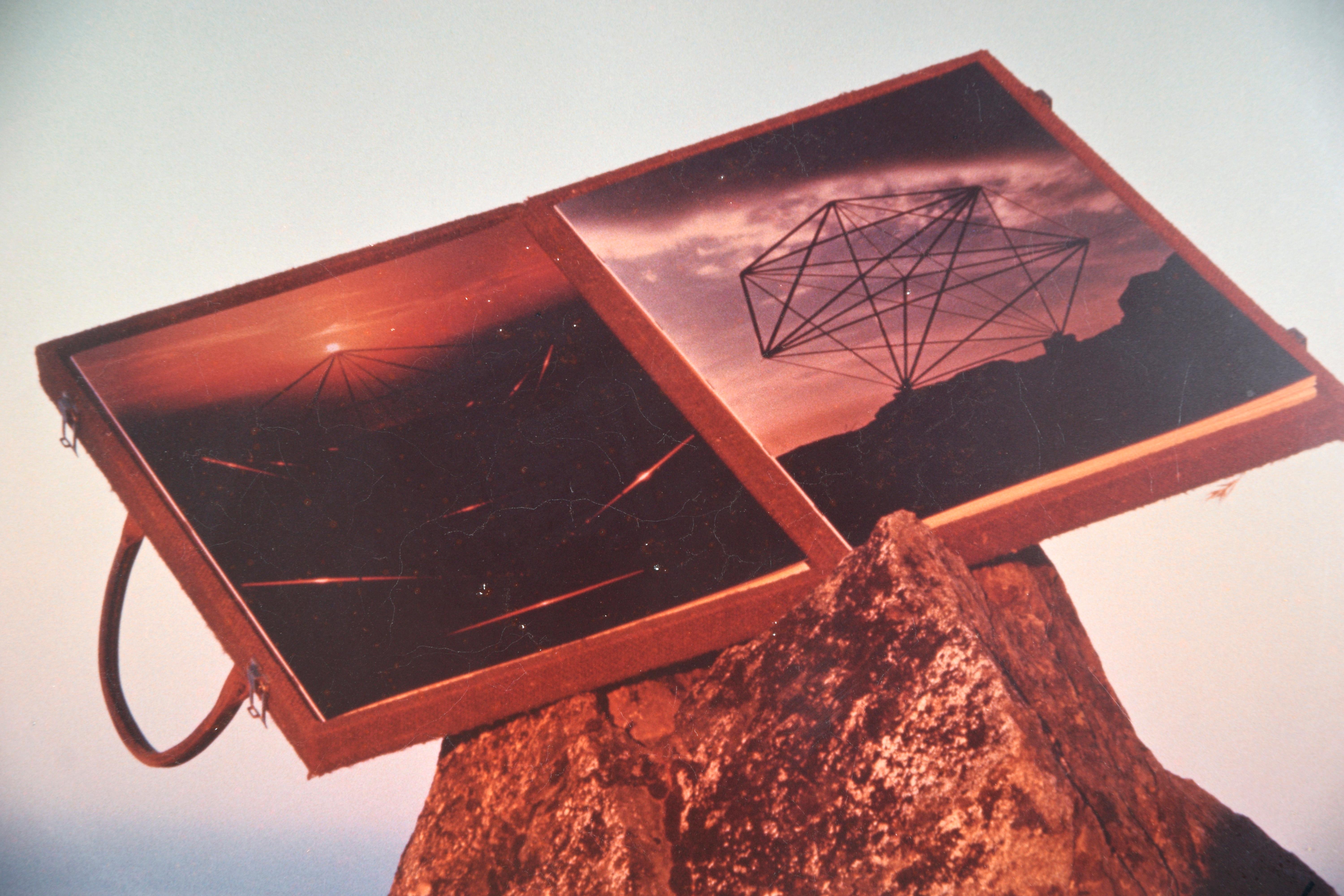 Formes géométriques avec paysage marin et lune - Photographie d'art ésotérique

Photographie d'un coffret ouvert présentant deux autres photographies de Y. Y. Meru (Américain né en 1923 et décédé en 2009). Le coffret est posé sur un rocher avec, en