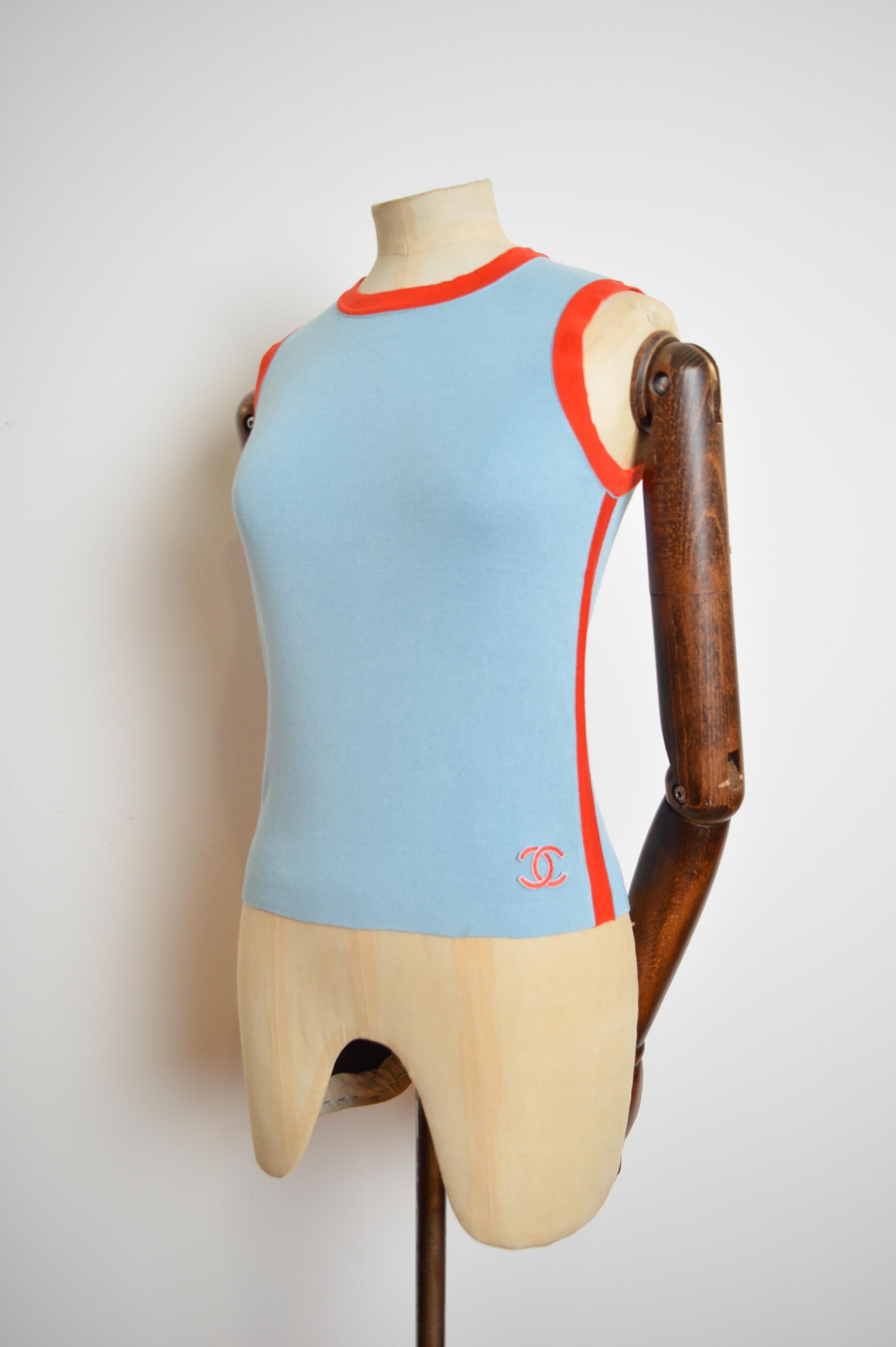 Vintage 2002 Chanel by Karl Lagerfeld knit Tank top in the Iconic pale blue and vibrant tangerine colour way.

The Garment features figure contouring shape with Orange piping detail down both the sides aswell as around the Collar, it also displays