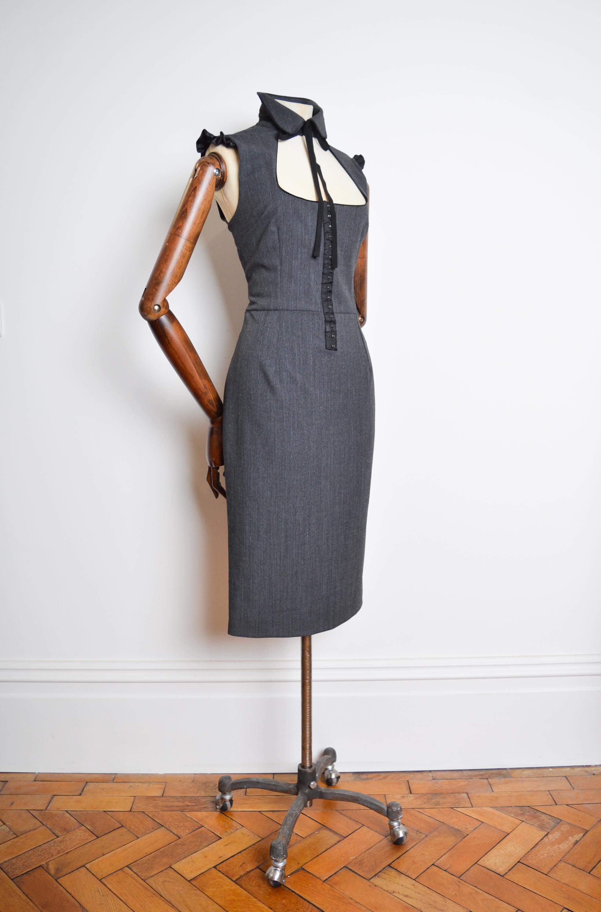 Elegant, Vintage DOLCE & GABBANA Dress, Circa 2009.  

This Luxurious, Key Hole Collared 'Peter Pan dress' is both Elegant and Sexy, crafted from a simple Pinstriped wool cloth, with a corseted waist line and to the Knee length hem.  

Our