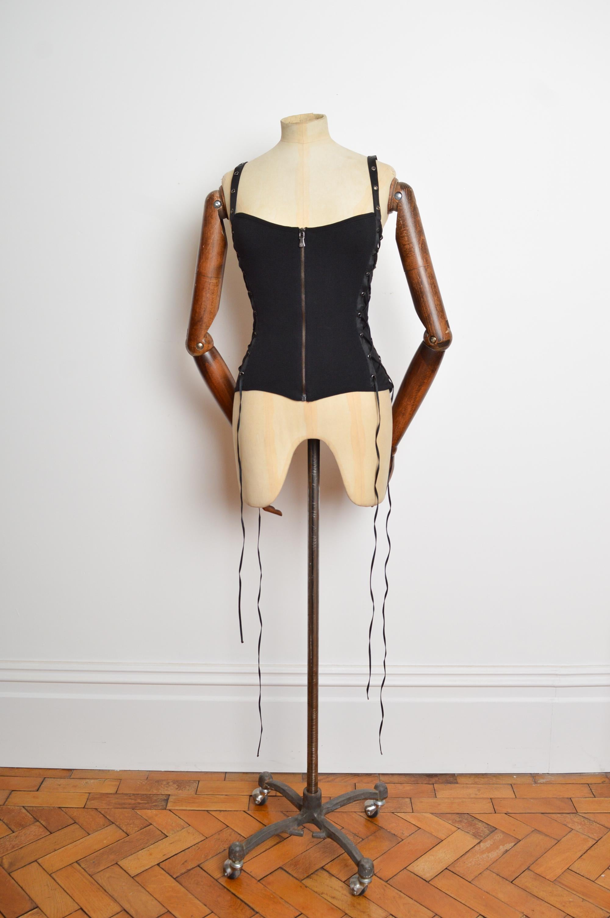 Donatella Versace 2000’s era Black lace up Camisole featuring a ribbed knit exterior intercepted with satin fabric, brass rivets and exposed gun metal zip down the front. Fabulous dressed both up or down. 
Recommended Size; Stretchy fabric will suit