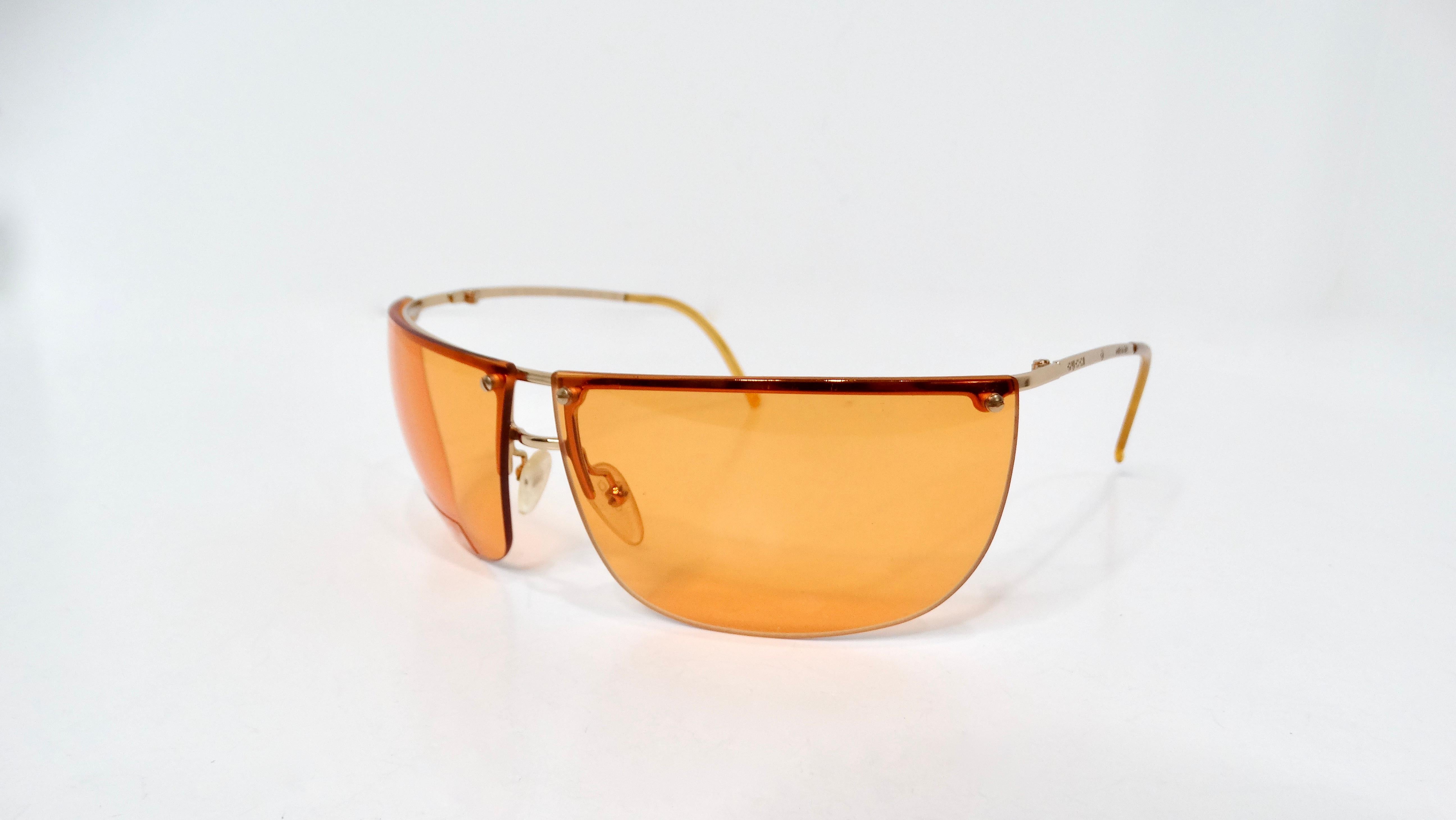 Gli occhiali da sole oversize Y2K Gucci Orange senza montatura in metallo dorato incarnano un'estetica audace e nostalgica che cattura l'essenza della moda dei primi anni 2000 con un tocco di lusso. Caratterizzati da una sorprendente tonalità