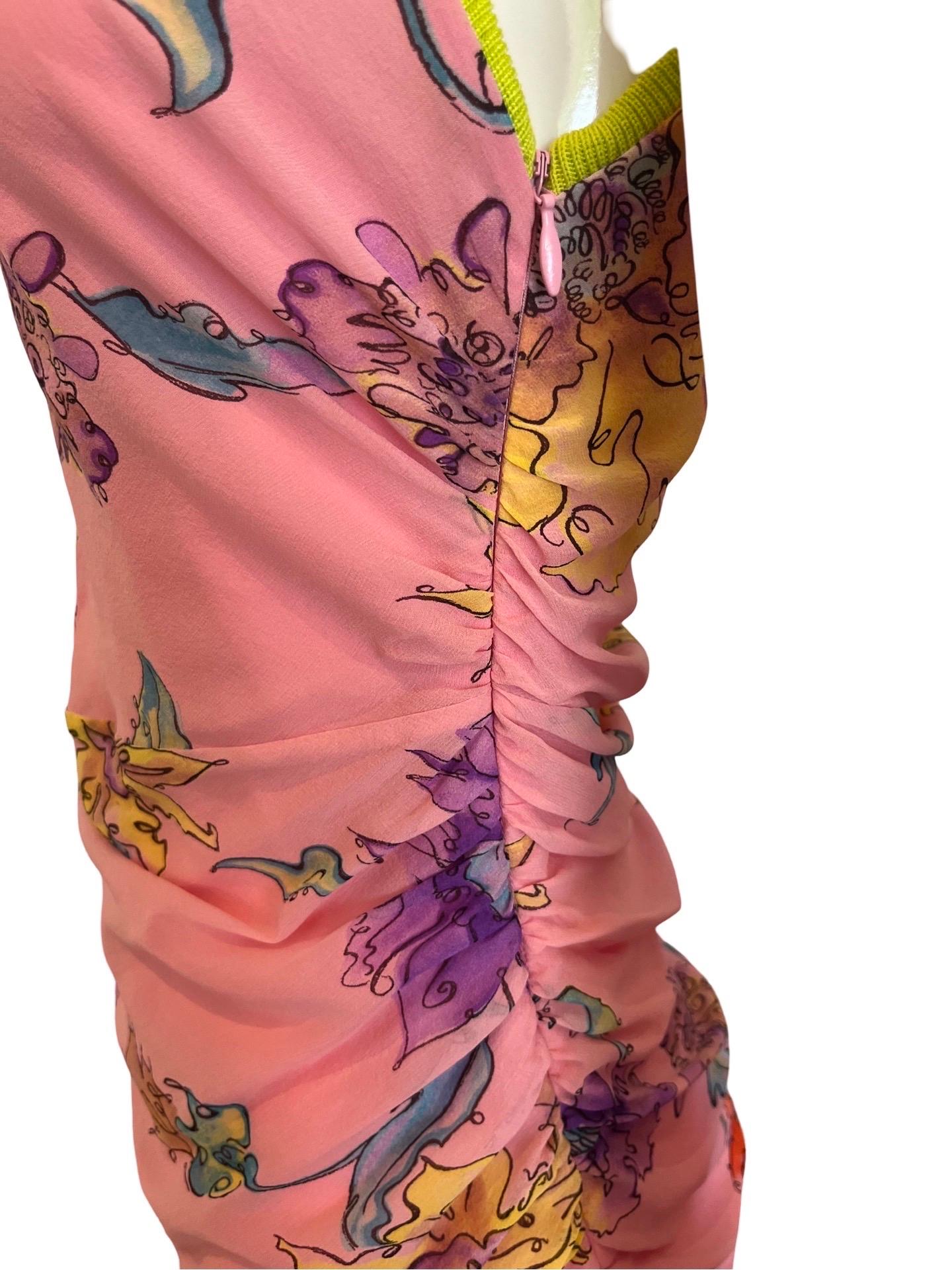 Fun and flirty summer dress from the Ungaro Fuchsia label of the early 2000's this dress is an outside layer of floral pink silk, ruched along the sides in the middle for a form fitting silhouette. The lining is a polyester pink and the trim along