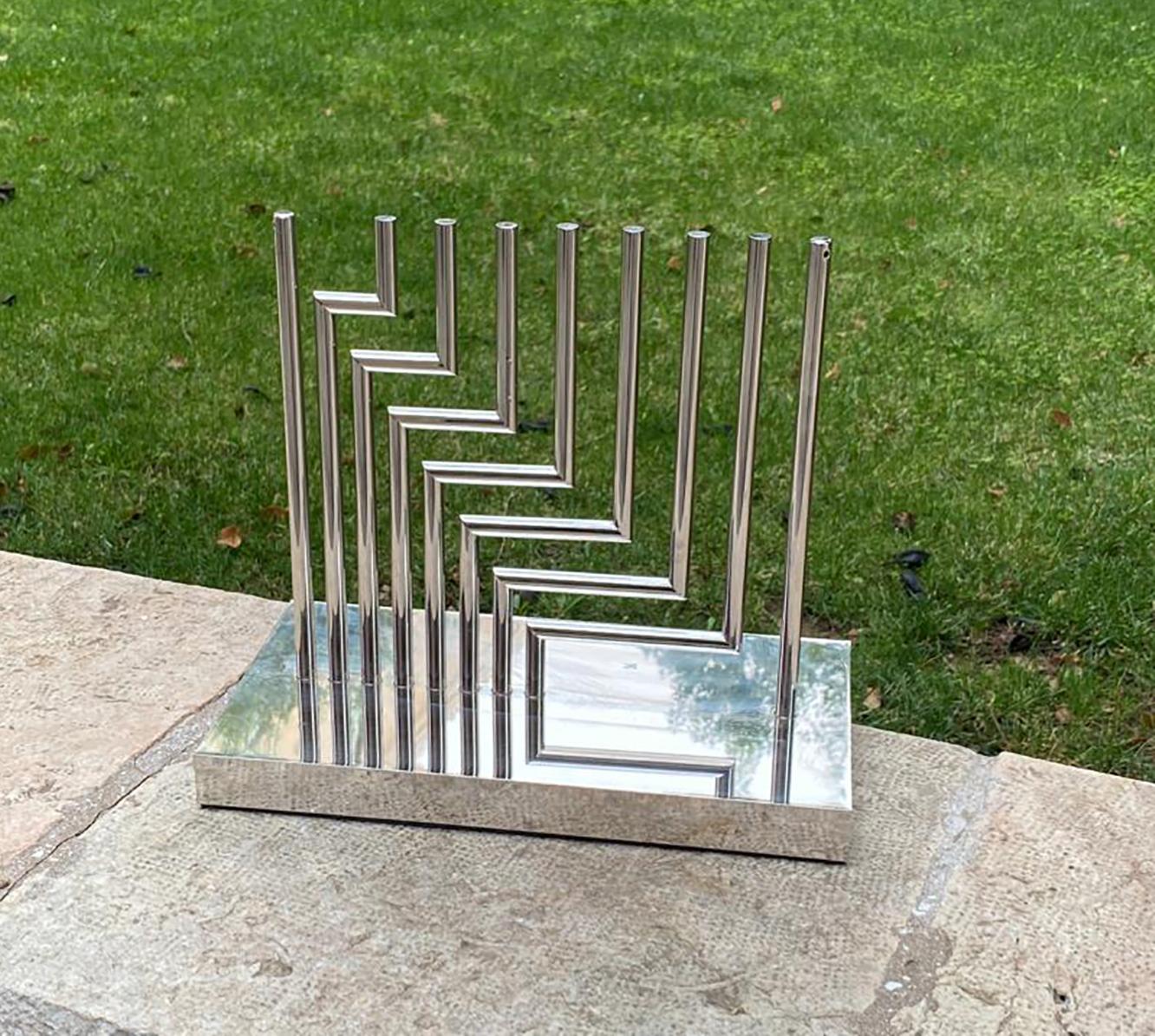 Brass silver colored Kinetic Chanukiah (Menorah) by the well known Israeli artist Yaacov Agam. the chanukiah comes with the candle holder. signed and numbered by the artist.

