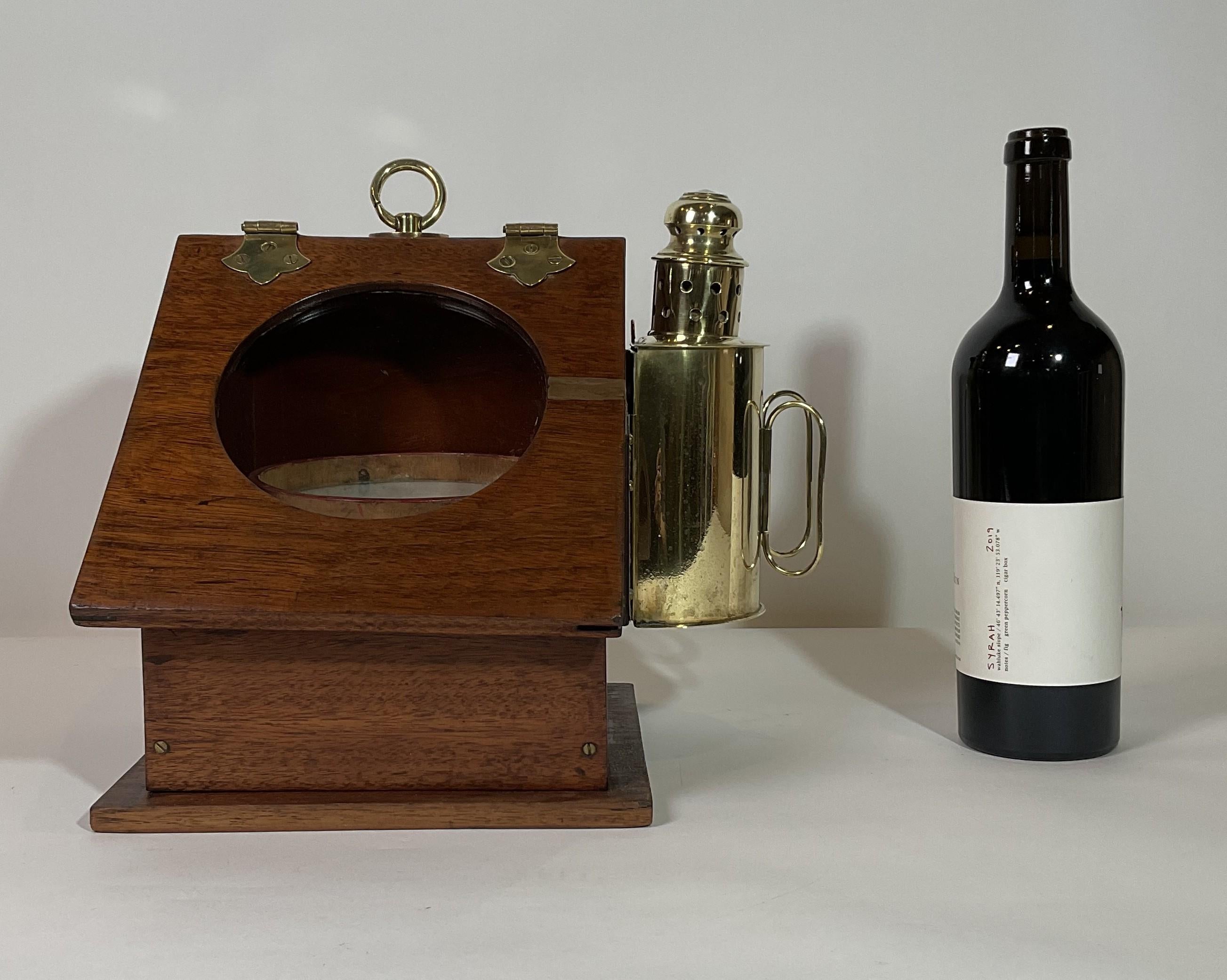 Binnacle de yacht du XIXe siècle avec un compas à cartes sèches dans un bol en bois. La boussole a été inclinée pour permettre une visualisation décorative. Couvercle incliné avec fenêtre de visualisation ronde. Une lampe à huile en laiton massif
