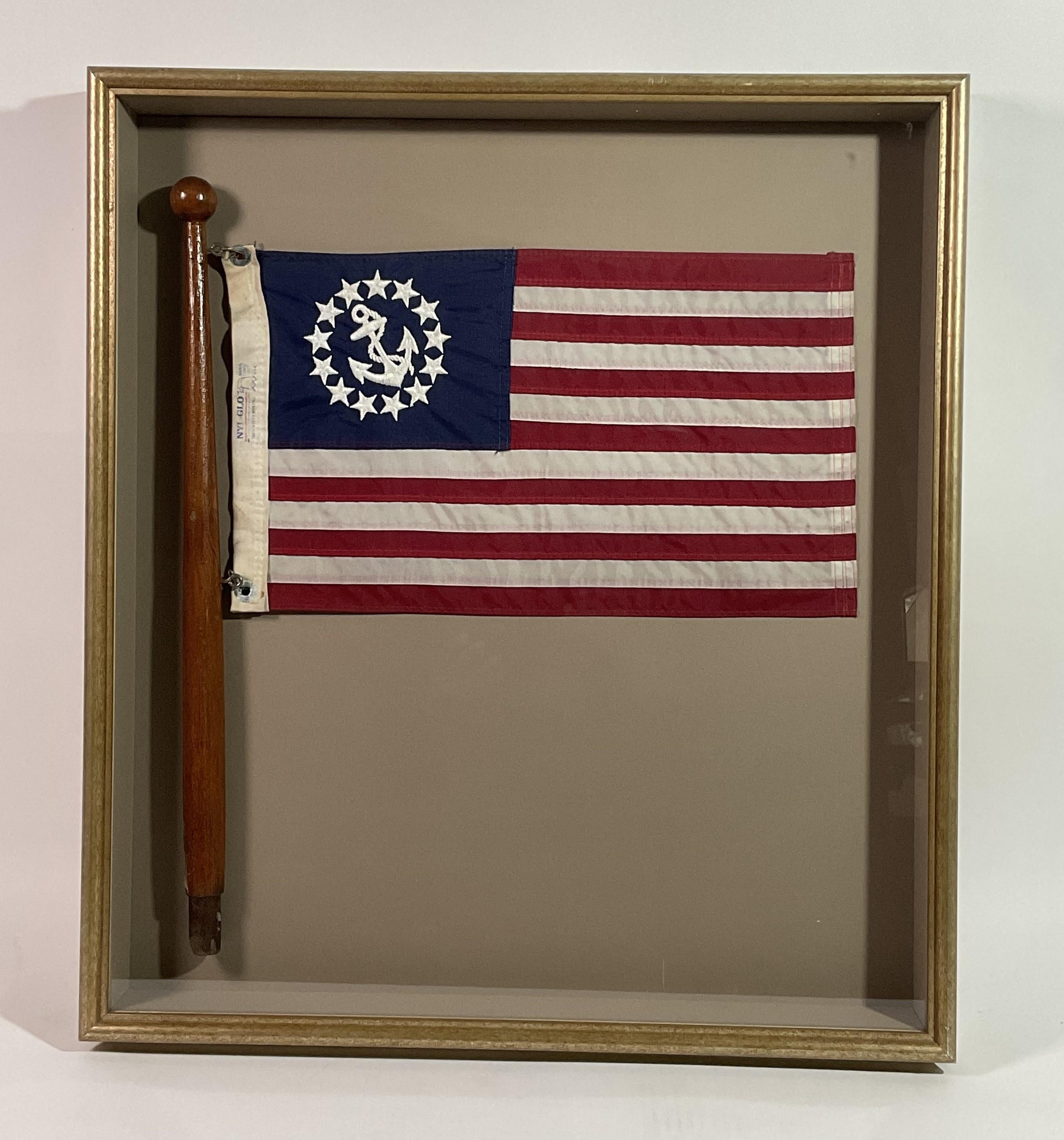 Caja de sombra con una bandera náutica que tiene un ancla bordada y estrellas en el campo azul, sujeta a un asta barnizada colocada en un marco de caja de sombra. Gran acento náutico.

Peso:    13 lbs.
Dimensiones generales:    30 